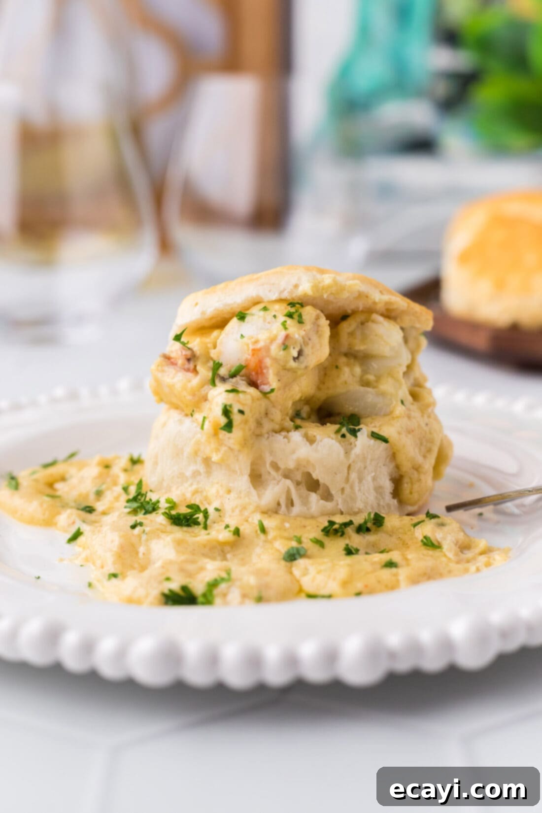 Velvet Lobster Delight 3 A close-up of a serving of Lobster Newburg nestled on an open, toasted biscuit.