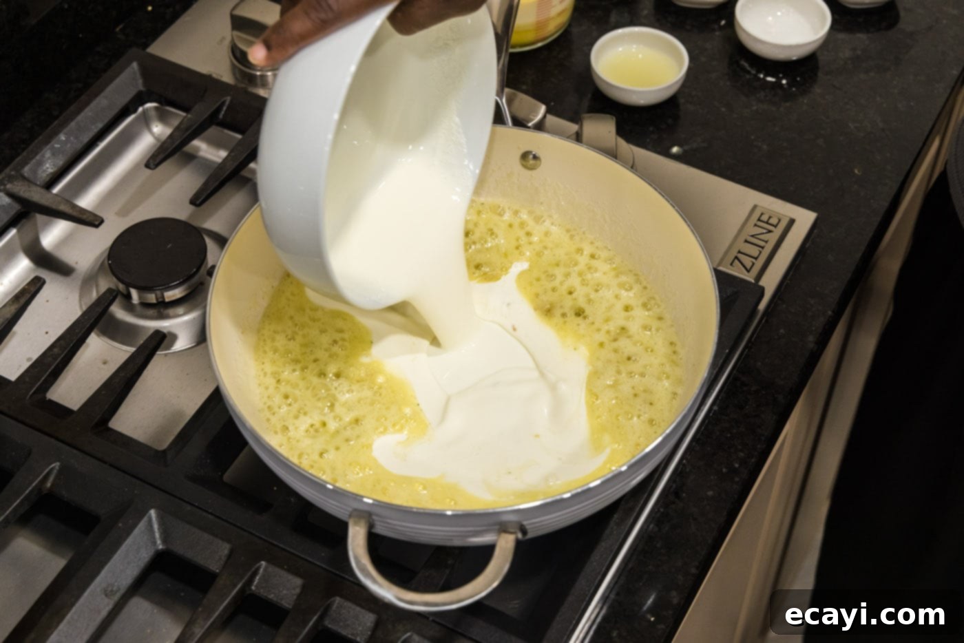 Velvet Lobster Delight 10 Pouring heavy cream into the skillet with the garlic butter and flour mixture.