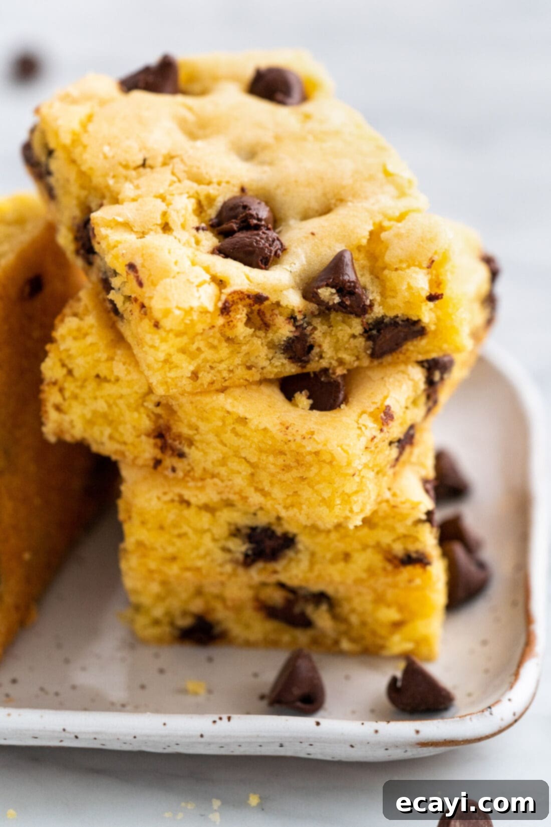 Easy Cake Mix Cookie Bars 3 A stack of perfectly baked Cake Mix Cookie Bars, showcasing their soft interior and generous amount of chocolate chips, ready for serving.