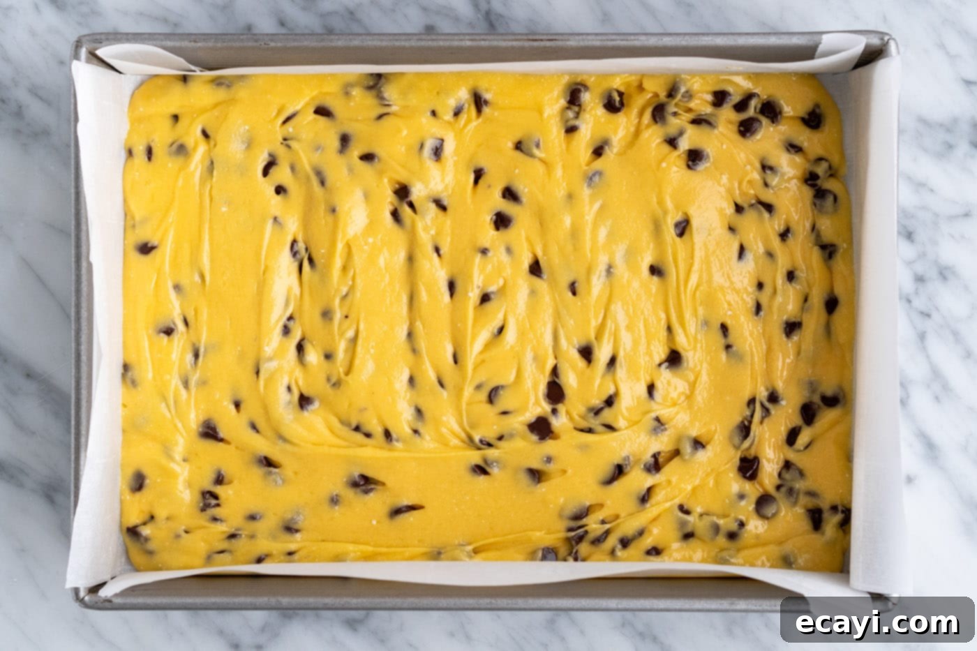 Easy Cake Mix Cookie Bars 10 Cake mix cookie bar batter smoothly spread out to fill a 9x13 inch baking pan, ready for additional toppings.