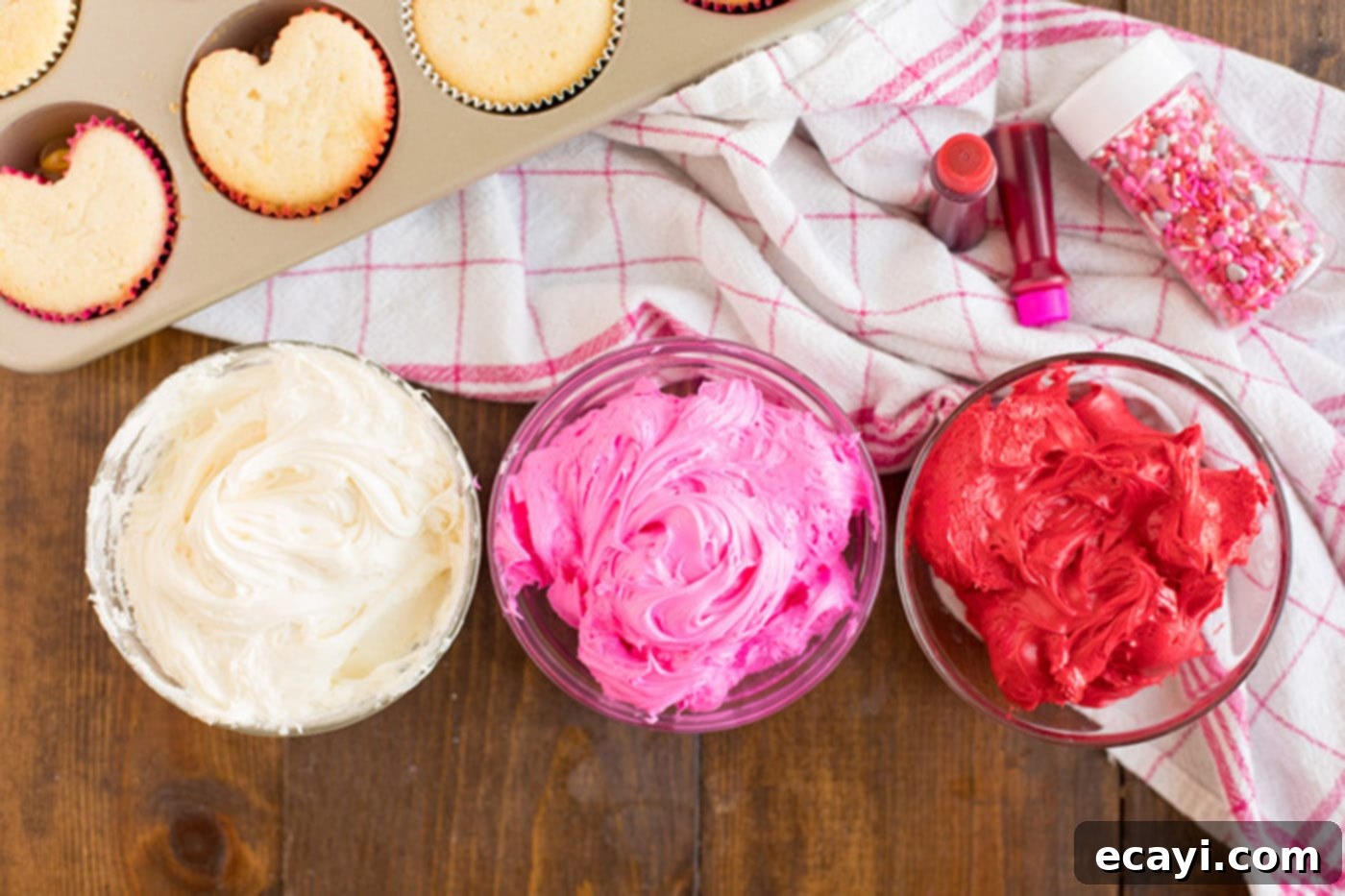 Heartfelt Valentine Cupcakes 10 Three bowls of white, pink, and red frosting, neatly separated and colored for decorating.