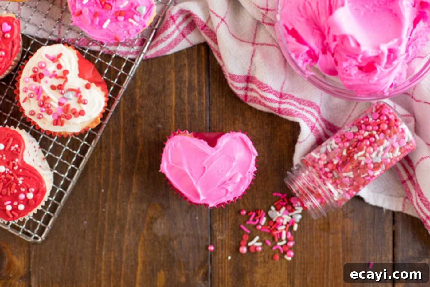 Heartfelt Valentine Cupcakes 11 A Valentine Heart Cupcake frosted with pink frosting and adorned with sprinkles on the side, ready to be enjoyed.
