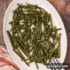 Crispy Roasted Green Beans 12 Roasted Green Beans on a serving platter with a serving fork, ready to be enjoyed