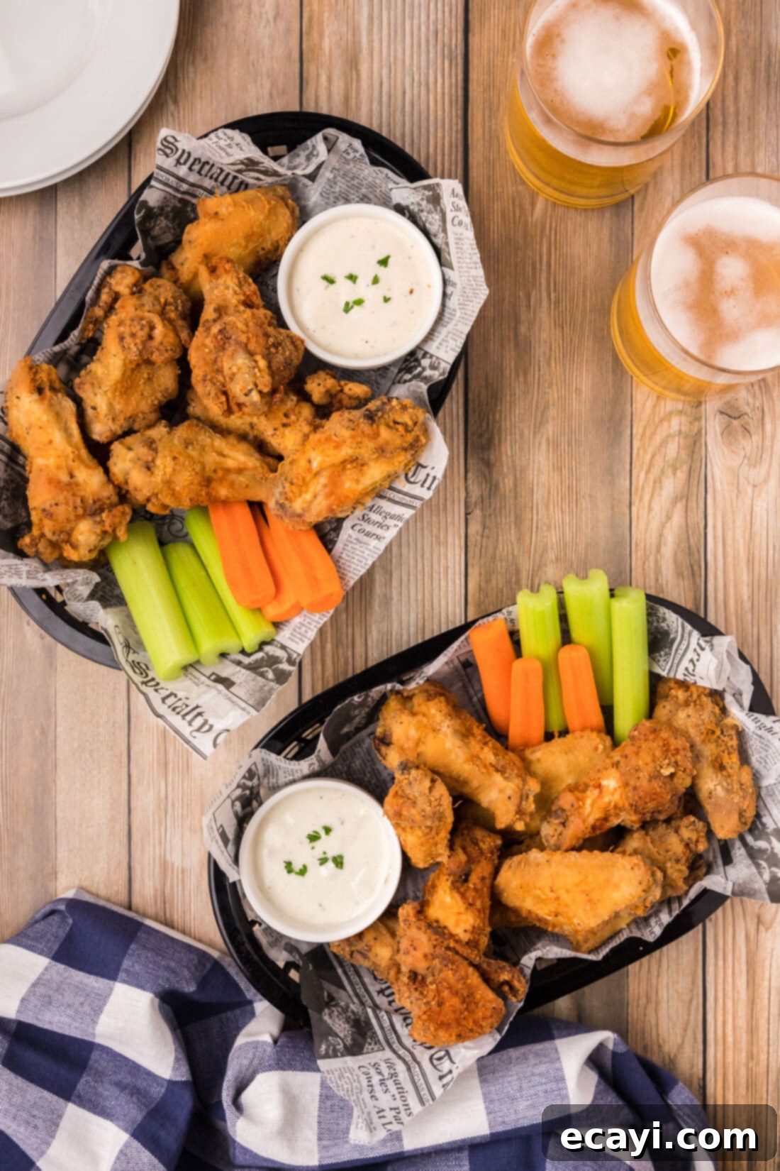 Crispy Fried Chicken Wings 2 Two baskets of Fried Chicken Wings with carrots, celery and ranch, ready to be served.
