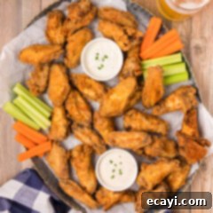 Crispy Fried Chicken Wings 14 Platter of Golden Fried Chicken Wings with carrots, celery, and small cups of ranch dressing for dipping.