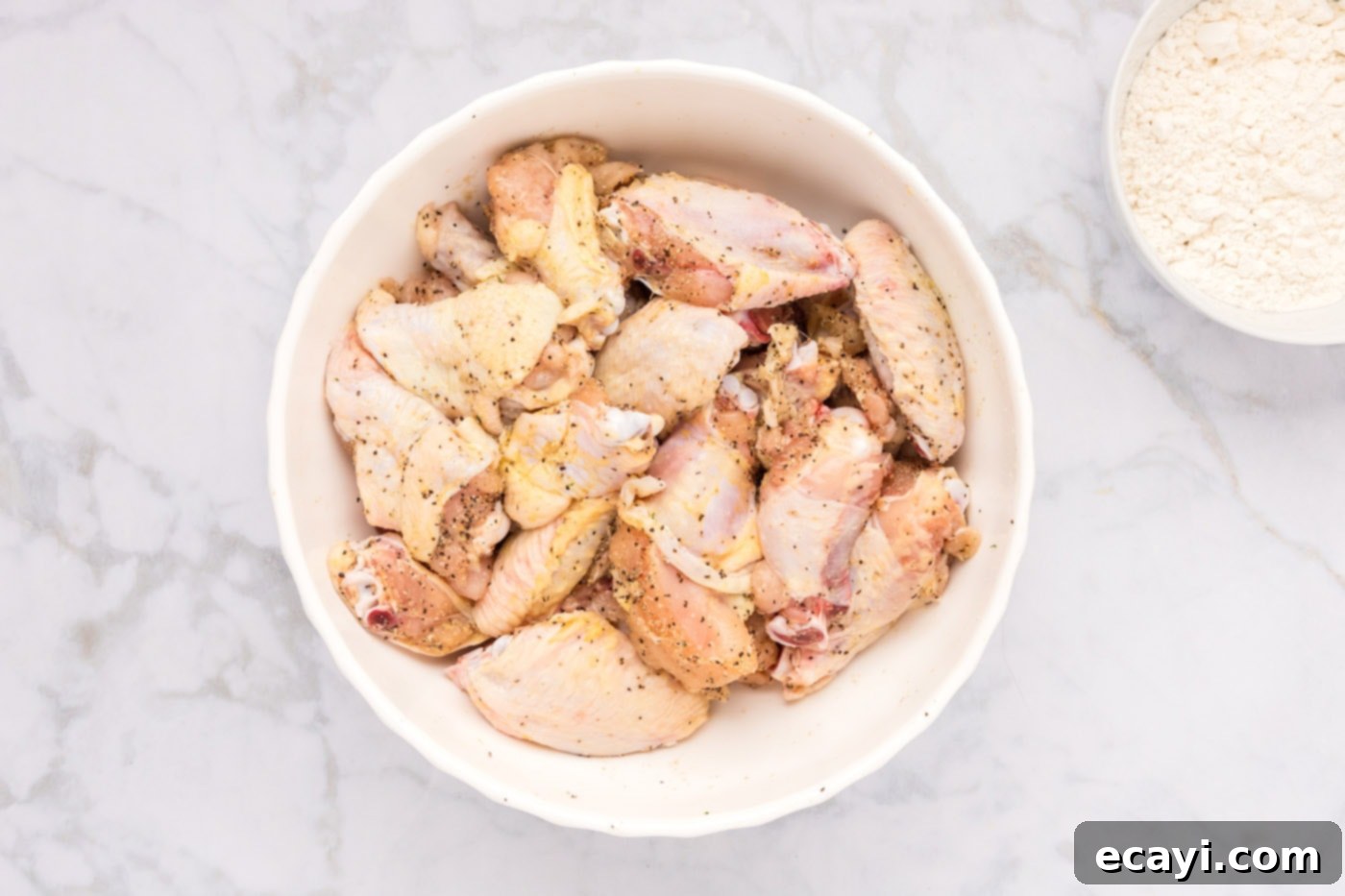 Crispy Fried Chicken Wings 5 seasoned chicken wings in a bowl, showing the spices rubbed into the meat.