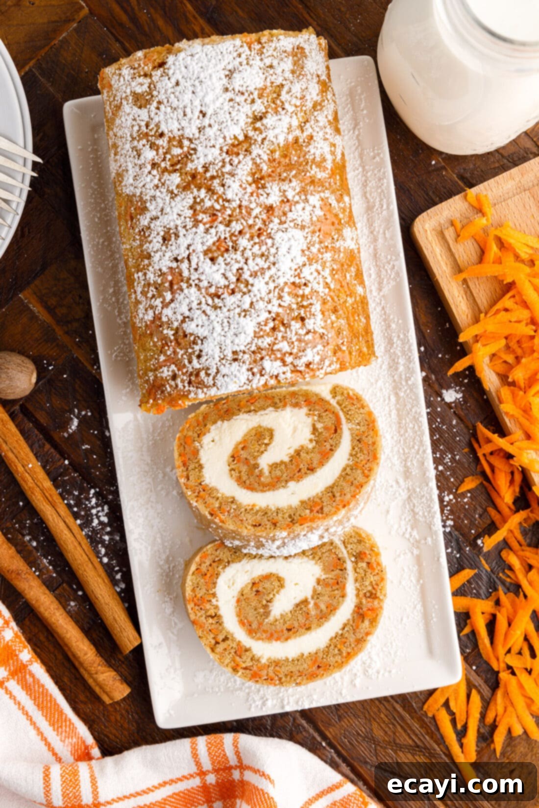 Swirled Carrot Delight 2 Sliced Carrot Cake Roll on a serving platter, showcasing its beautiful swirled design and cream cheese filling.