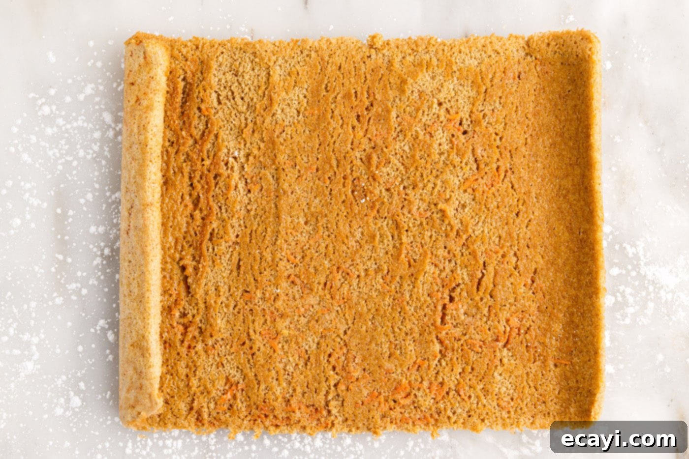 Swirled Carrot Delight 16 Unrolled carrot cake laid flat on a surface, ready for the cream cheese filling.