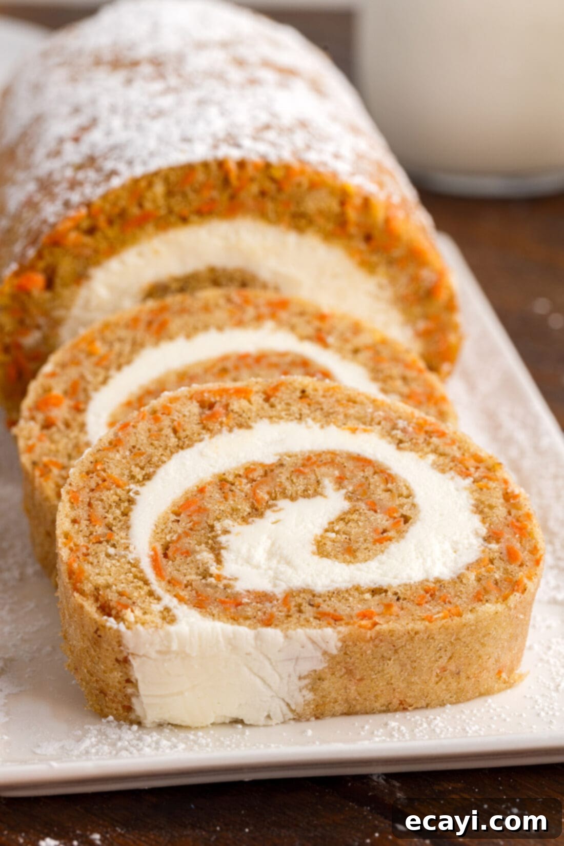 Swirled Carrot Delight 20 Carrot Cake Roll dusted with powdered sugar, showcasing its elegant presentation before slicing.