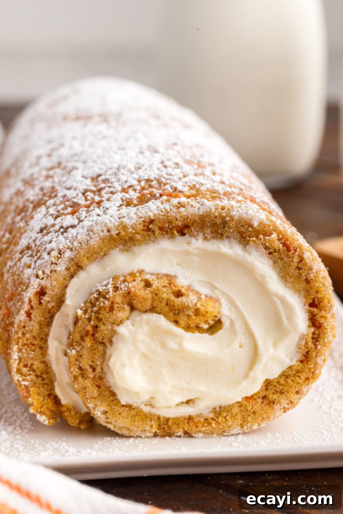Swirled Carrot Delight 3 Side view of a perfectly rolled Carrot Cake Roll, showing the seamless transition of cake and frosting.