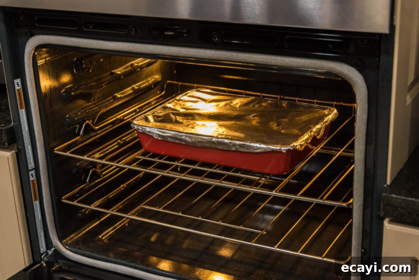 Tender Boneless Beef Short Ribs 11 Boneless beef short ribs baking slowly in the oven, covered with aluminum foil, transforming into a tender meal.