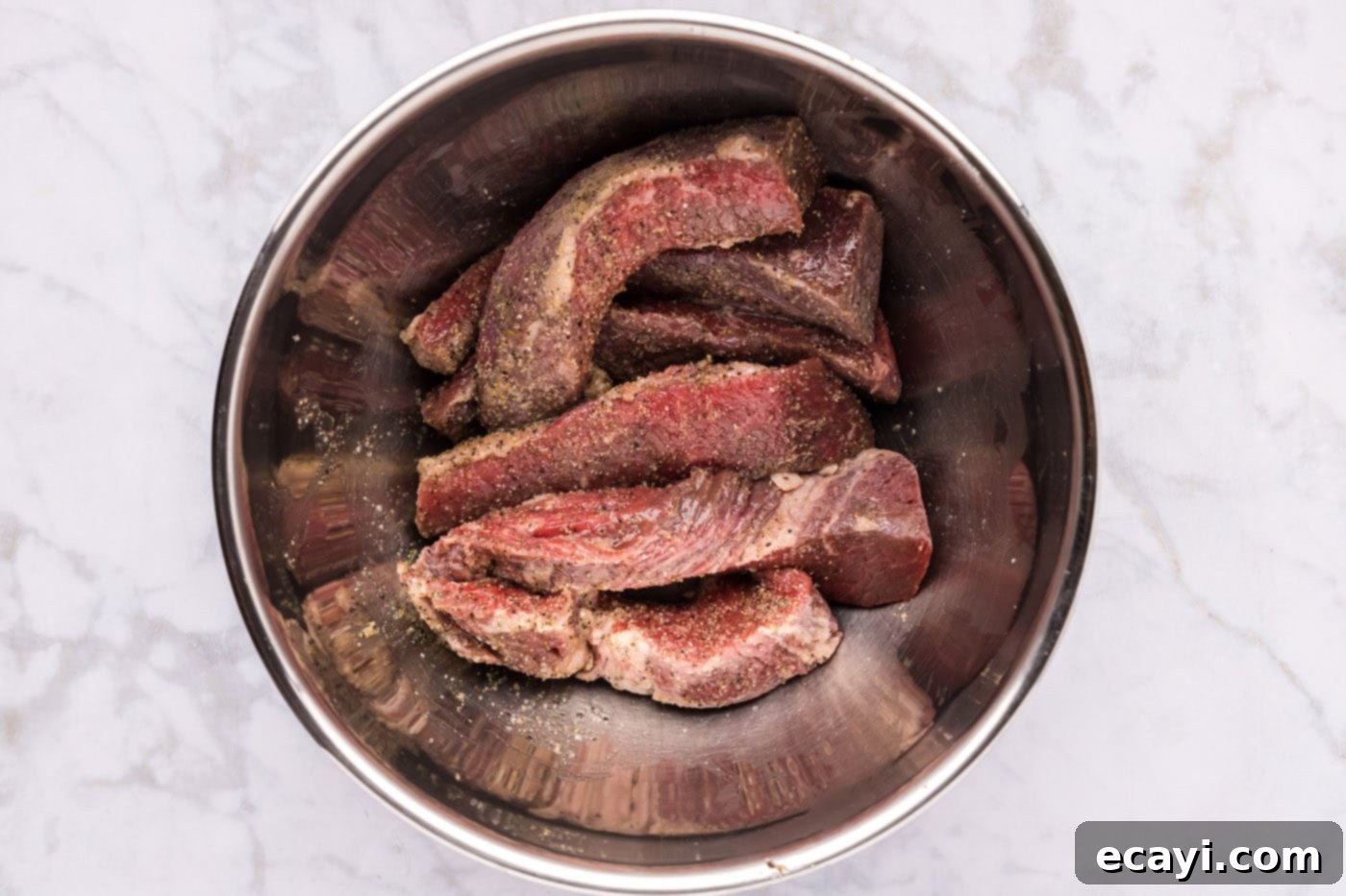 Tender Boneless Beef Short Ribs 6 Well-seasoned boneless beef short ribs in a mixing bowl, glistening and ready for the next step.