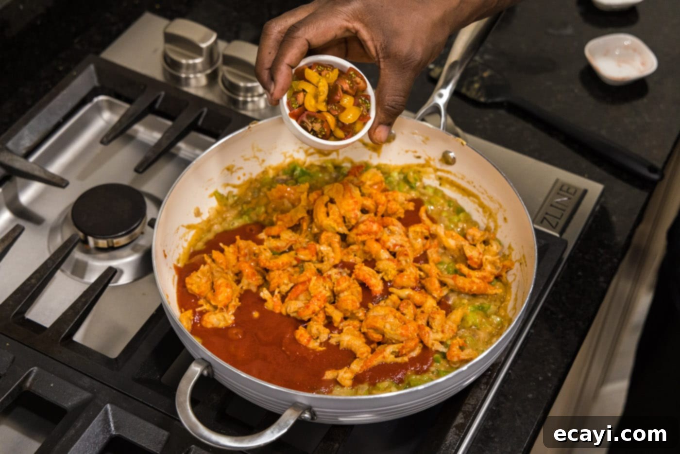 Crawfish Etouffee: A Taste of Louisiana 13 adding cherry tomatoes to crawfish etouffee in a skillet