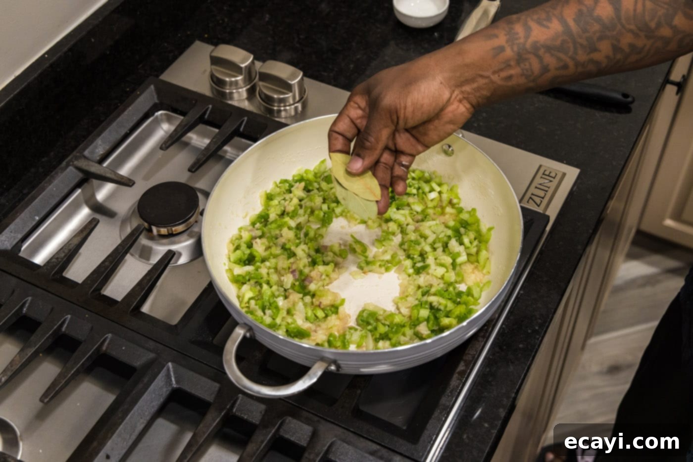 Crawfish Etouffee: A Taste of Louisiana 9 adding bay leaves to skillet of onion, bell pepper, and celery