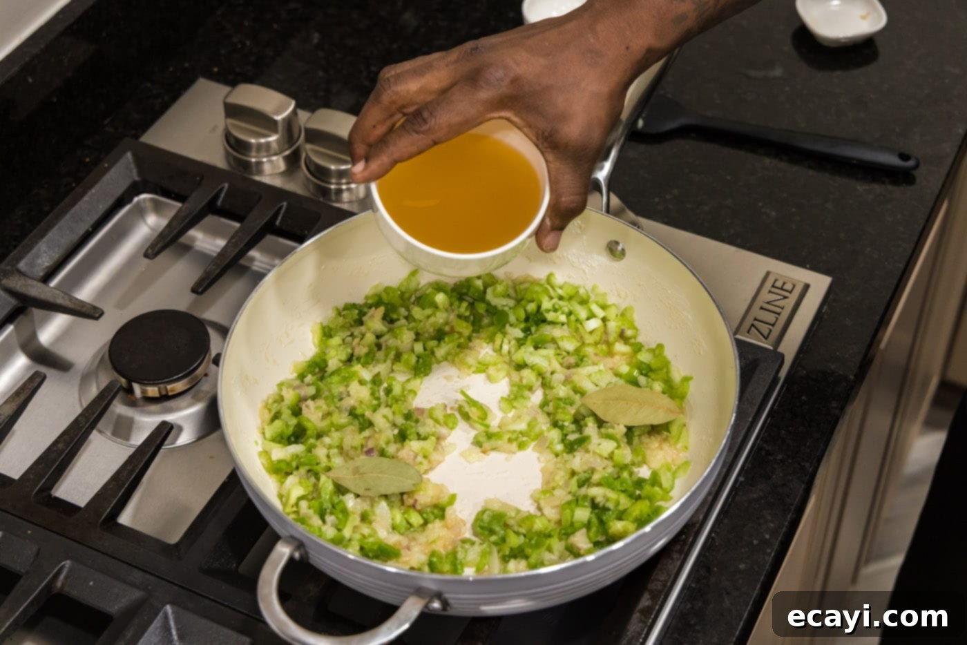 Crawfish Etouffee: A Taste of Louisiana 10 adding chicken stock to skillet of holy trinity vegetables