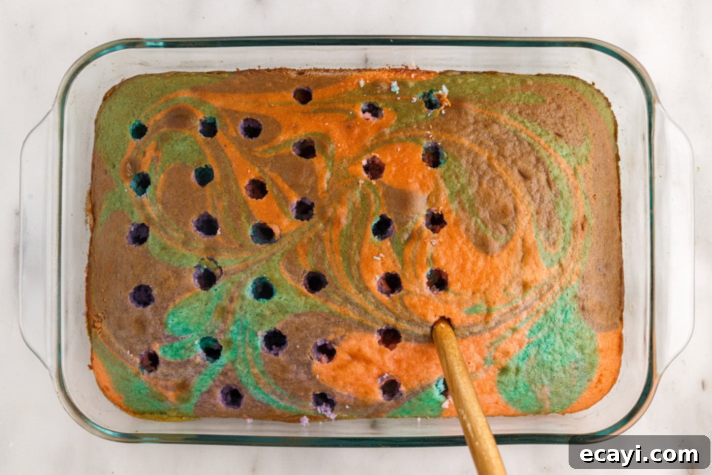 Springtime Poke Cake Delight 12 poking the top of a cake with a wooden spoon