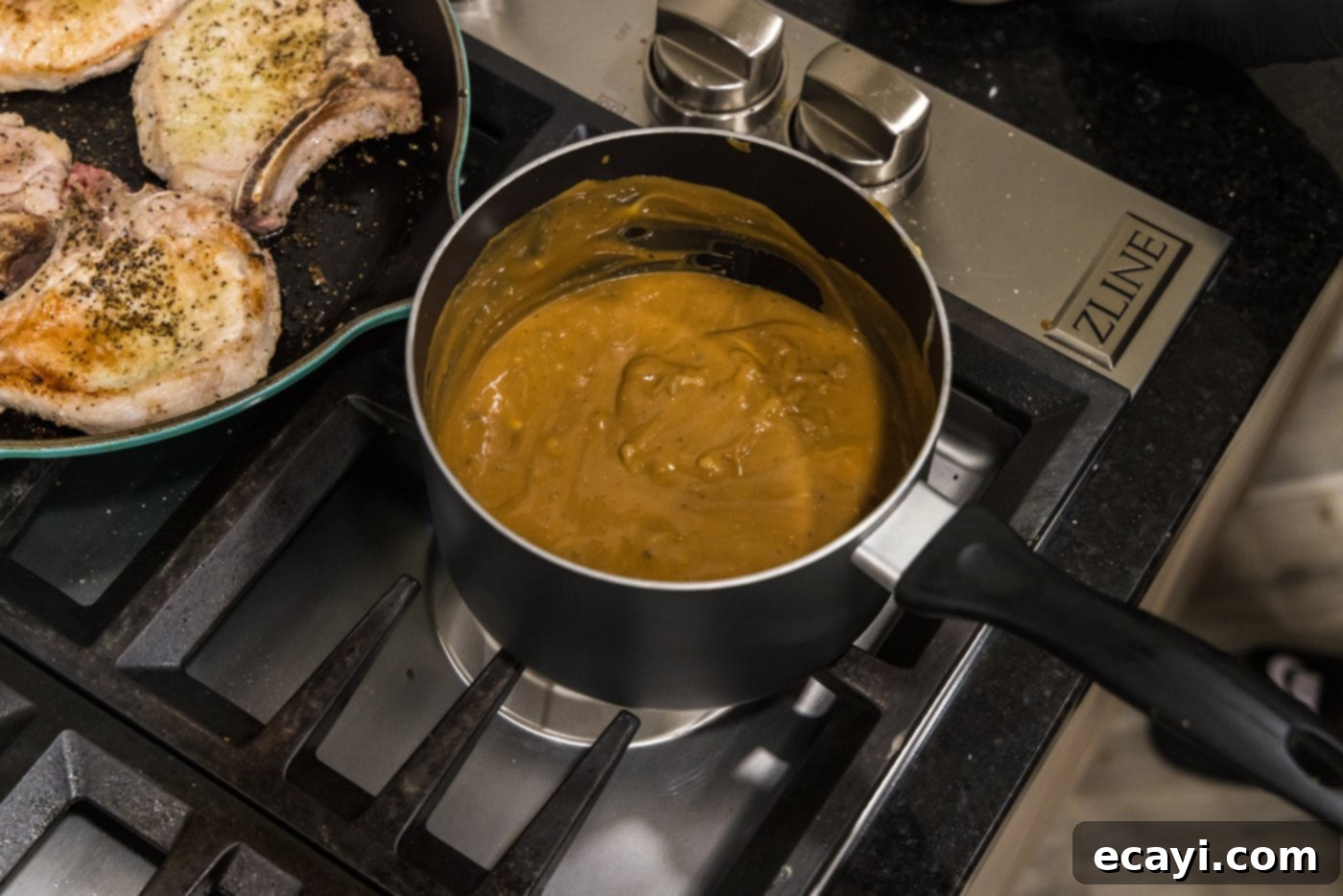 Fall-Off-The-Bone Pork Chops 9 Smooth, brown gravy simmering gently in a saucepan