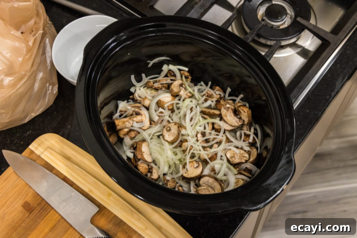 Fall-Off-The-Bone Pork Chops 10 Sliced mushrooms and onions placed at the bottom of a slow cooker