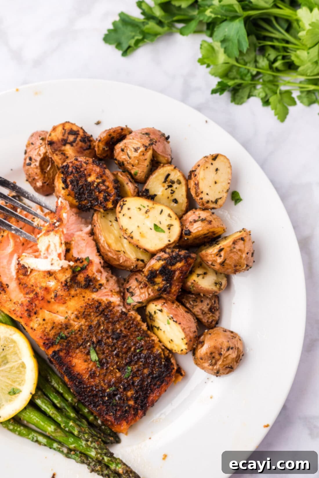Crispy Roasted Red Potato Medley 11 Roasted Red Potatoes on a plate with broiled salmon and asparagus, part of a balanced meal, ready to eat