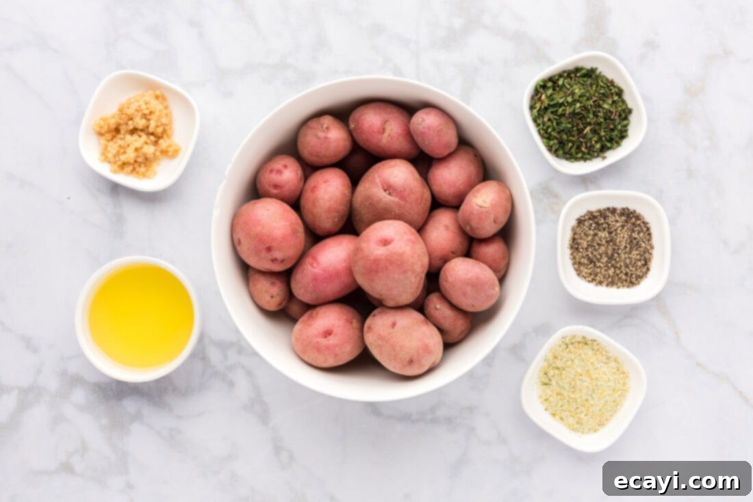 Crispy Roasted Red Potato Medley 4 Ingredients for Roasted Red Potatoes laid out on a table including potatoes, olive oil, garlic, thyme, and seasonings
