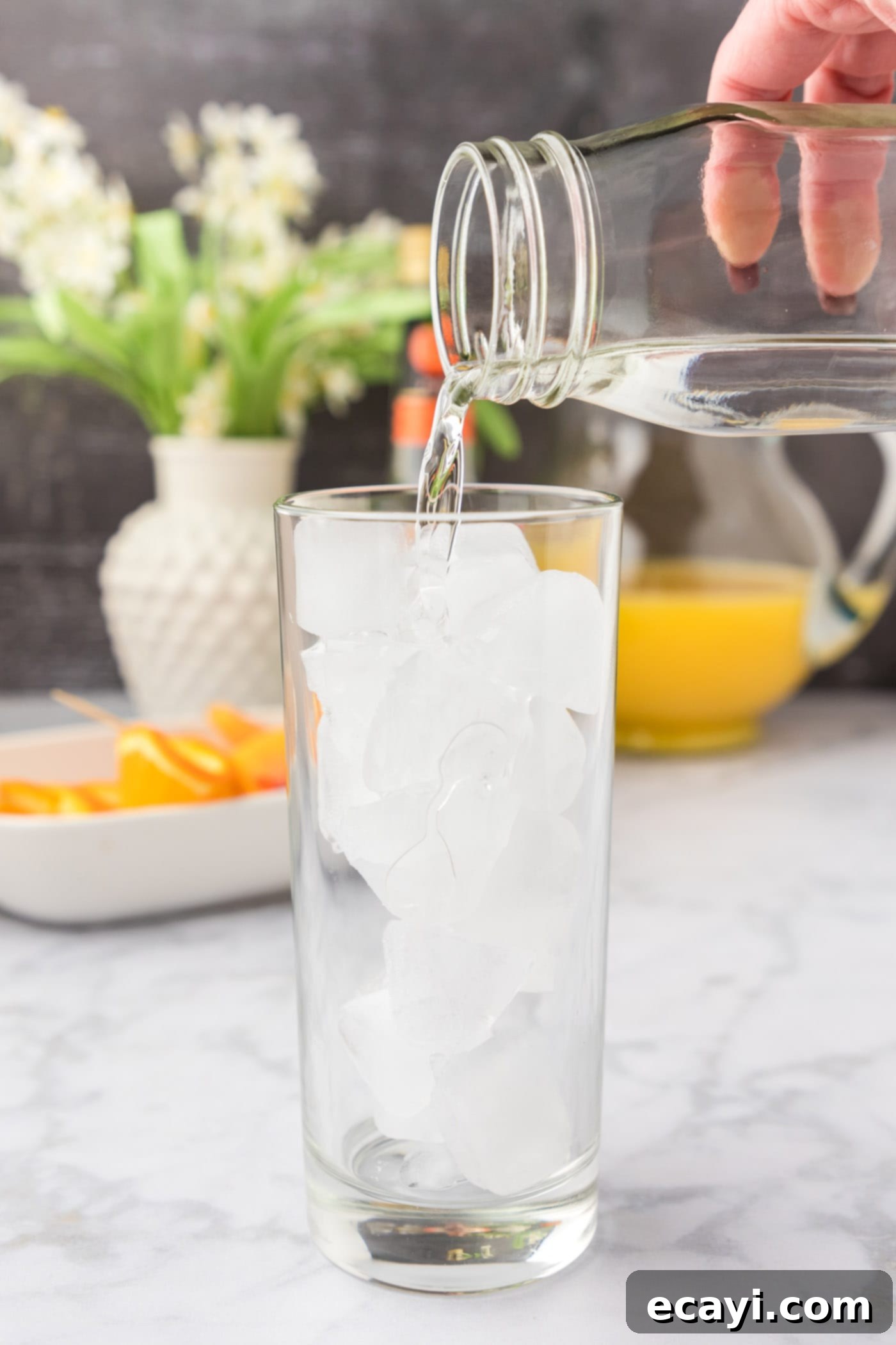 Golden Peach Nectar 5 pouring peach schnapps into glass of ice