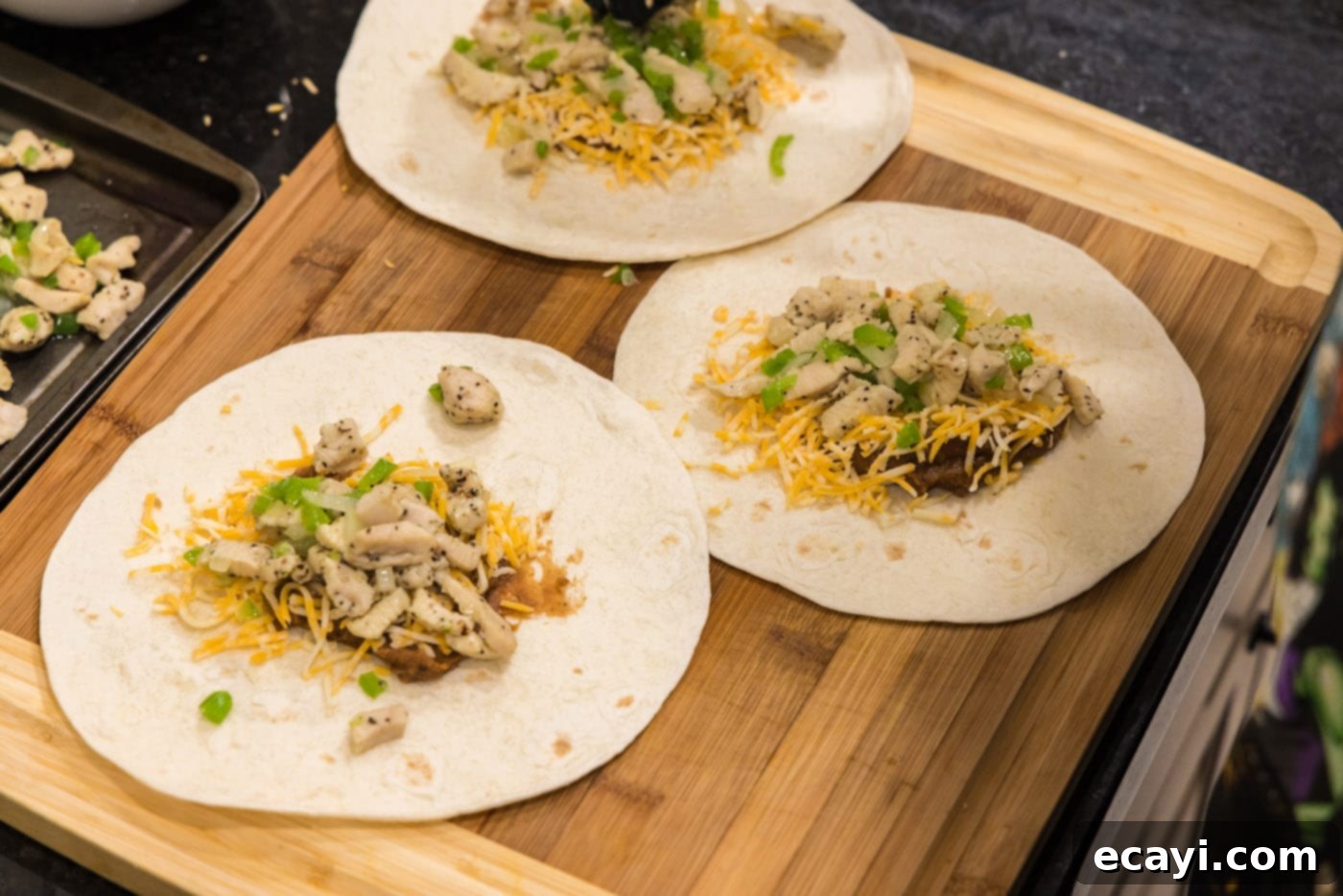 Chimichanga Perfection 13 Cooked chicken and vegetable mixture added as the top layer onto a tortilla with beans and cheese