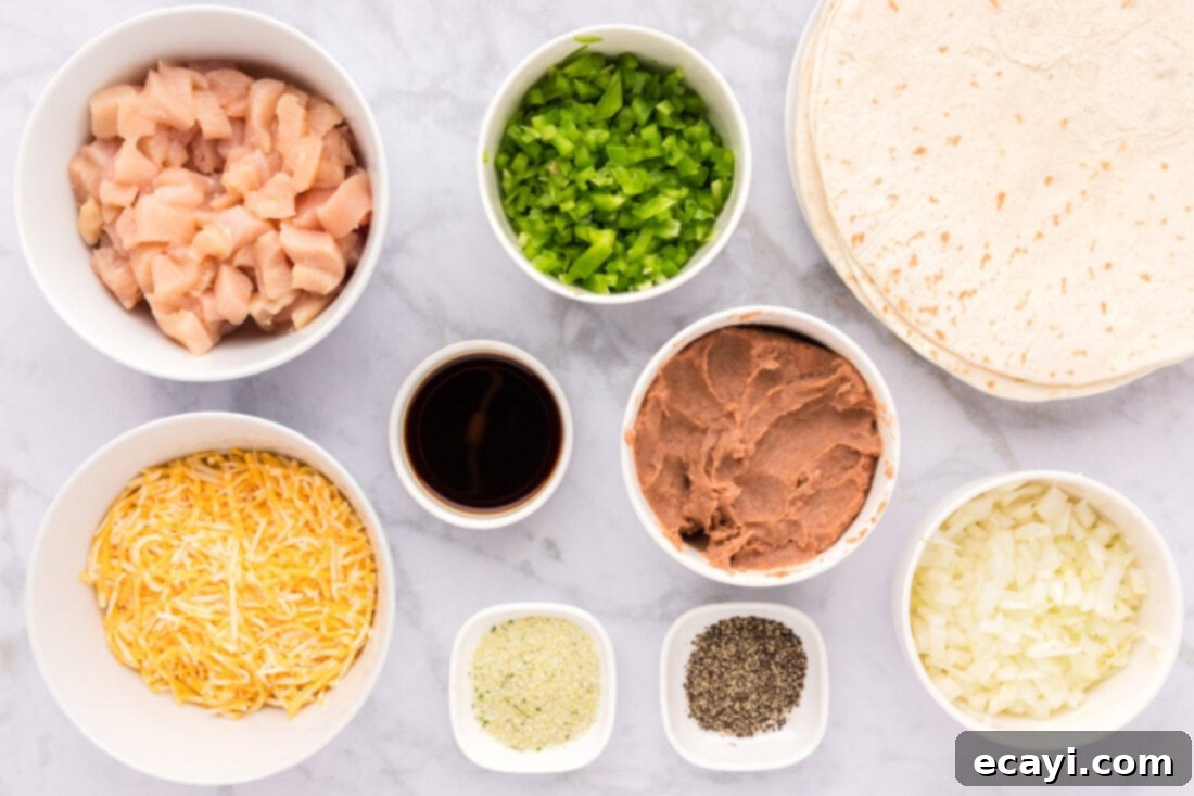 Chimichanga Perfection 4 A variety of fresh ingredients laid out for making chicken chimichangas, including chicken breast, bell peppers, onions, refried beans, cheese, and tortillas.
