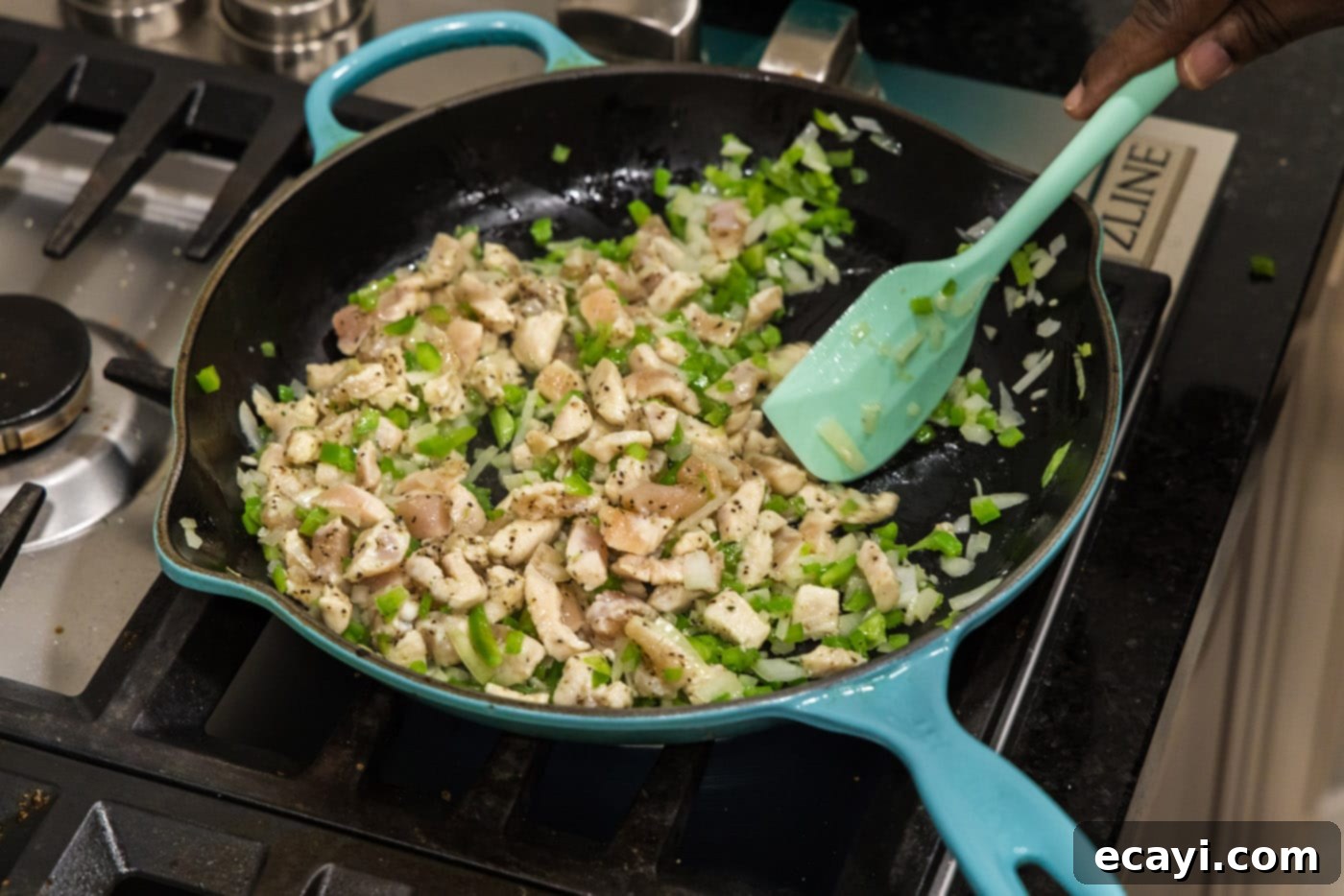 Chimichanga Perfection 10 Mixing chicken chunks with bell peppers and onions in a skillet until chicken is cooked through