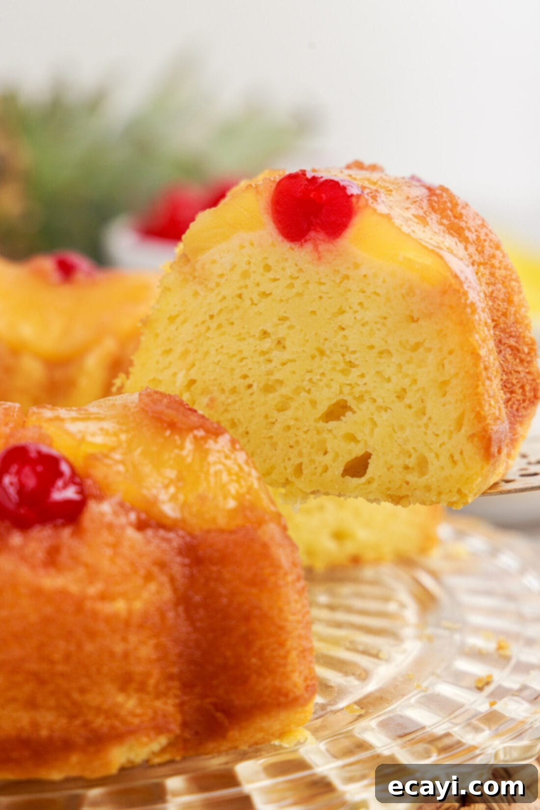 Golden Pineapple Crown Bundt Cake 3 Close up photo of a slice being removed from a Pineapple Upside Down Bundt Cake