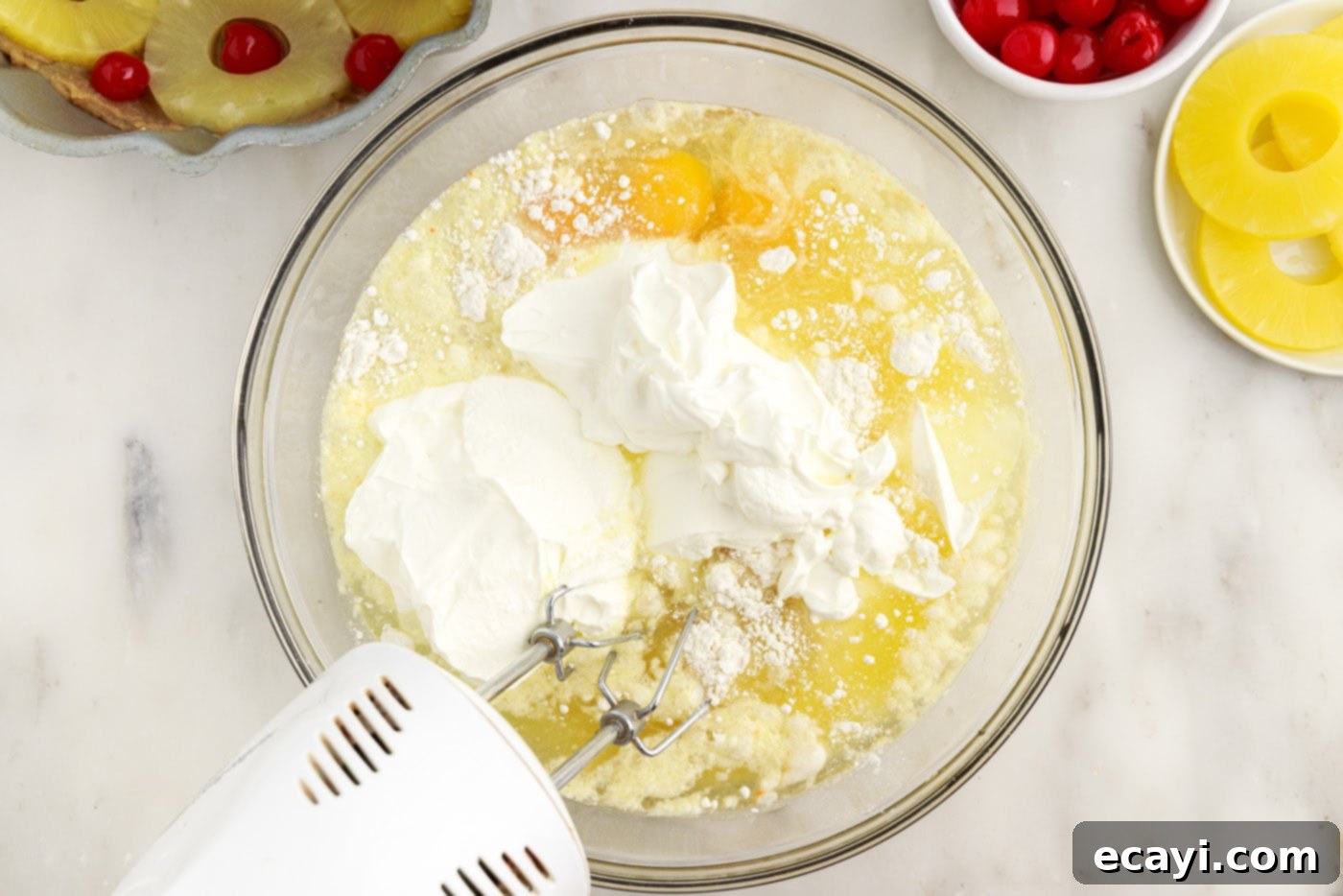 Golden Pineapple Crown Bundt Cake 10 mixing bundt cake ingredients with a handheld mixer