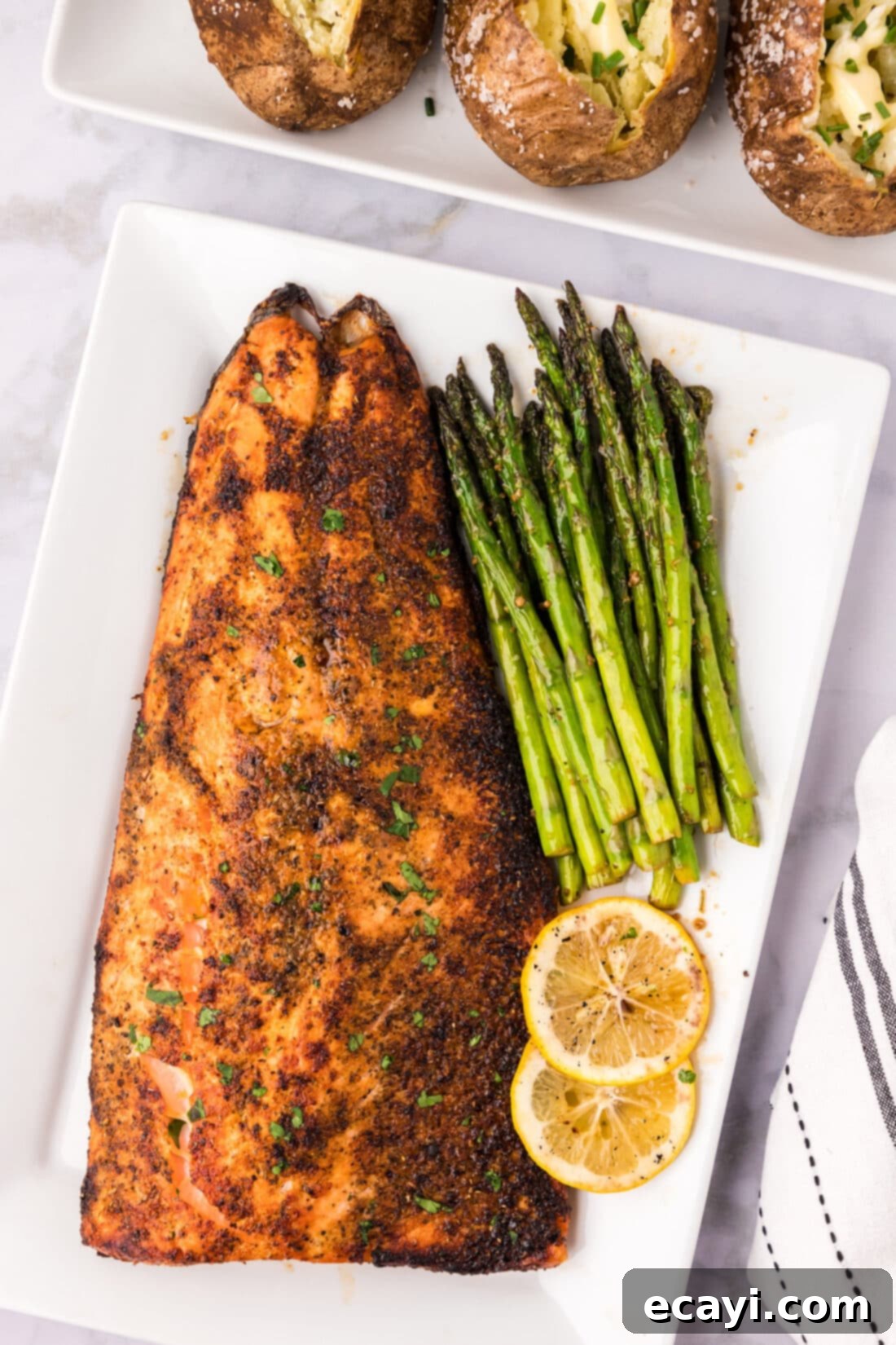 Perfectly Broiled Salmon 2 Broiled Salmon on a serving platter with sautéed asparagus and lemon slices