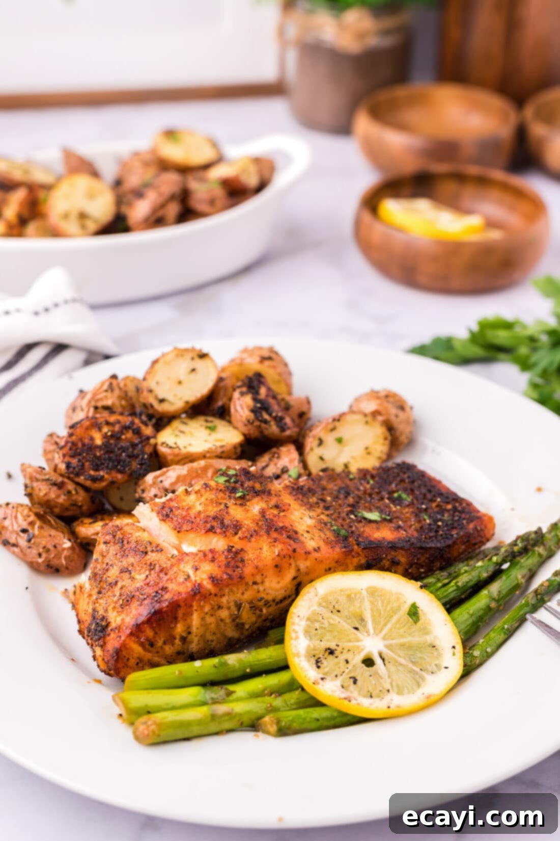 Perfectly Broiled Salmon 3 Slice of Broiled Salmon on a plate with sautéed asparagus and roasted red potatoes