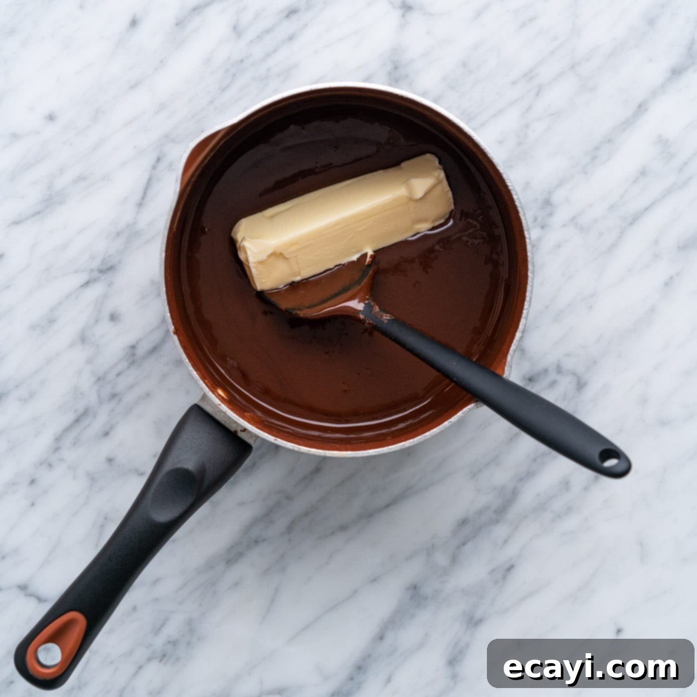 Decadent Chocolate Drizzle 8 adding butter to hot fudge in a pot
