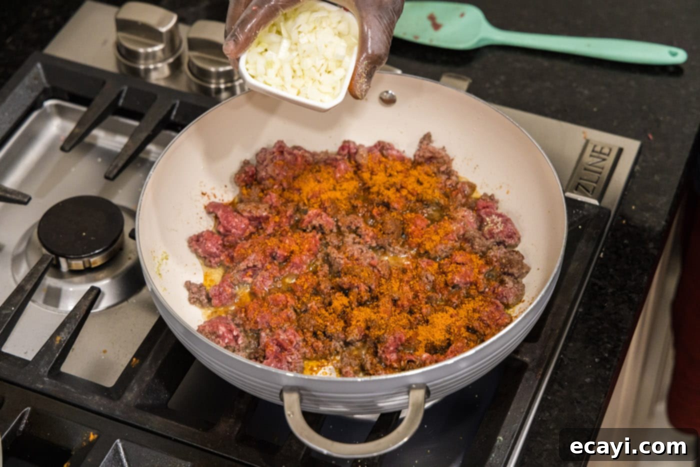 Tex-Mex Spaghetti 6 adding chopped onion to skillet with ground beef