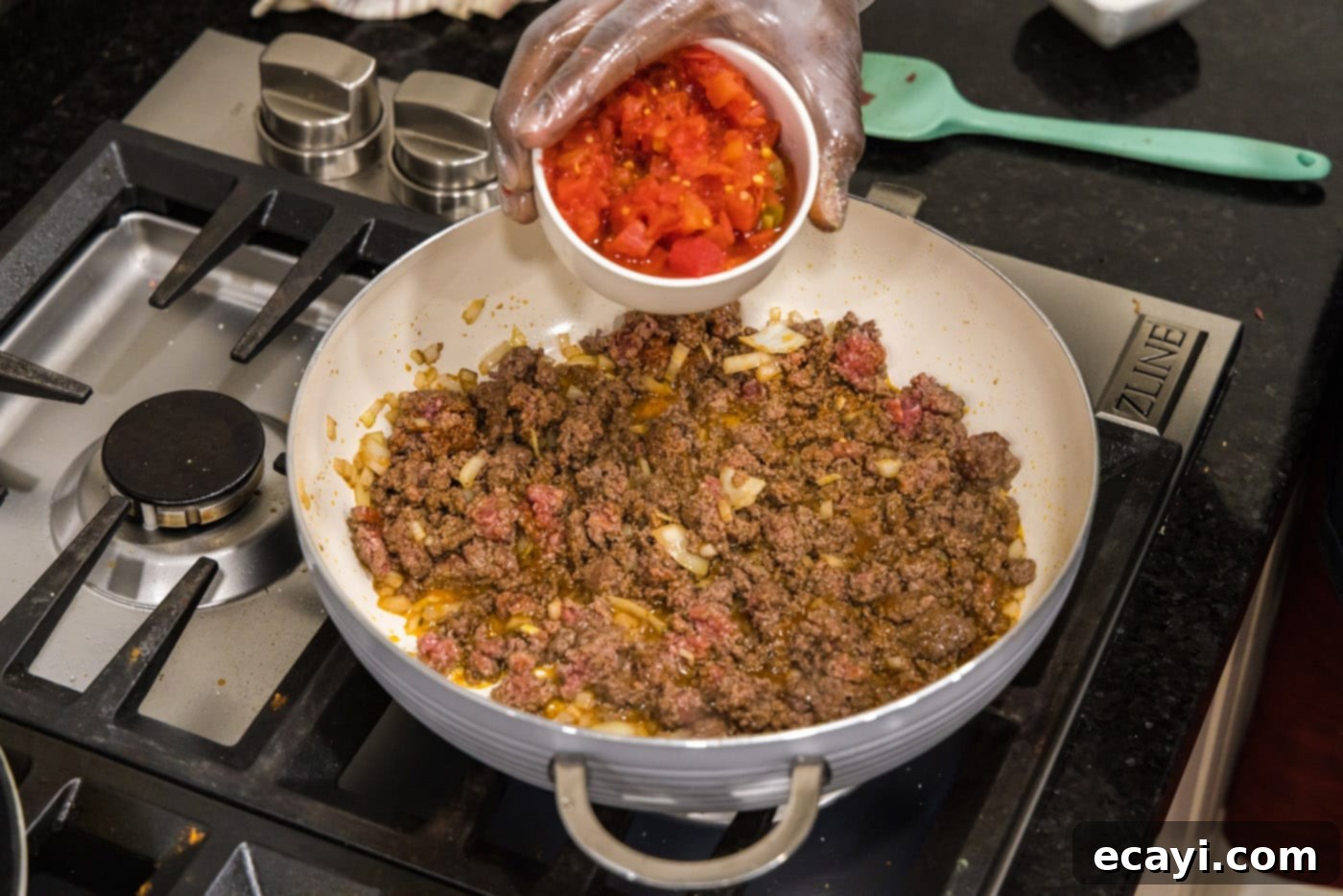 Tex-Mex Spaghetti 7 adding Rotel tomatoes to skillet with ground beef and onion
