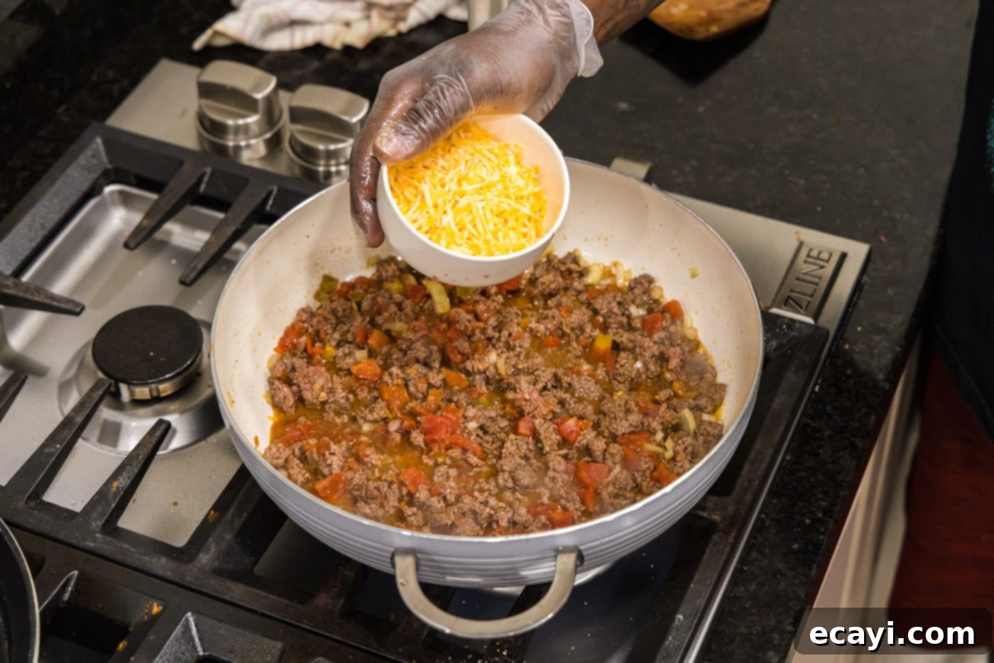 Tex-Mex Spaghetti 8 adding cheese to skillet with ground beef, onion, and tomatoes