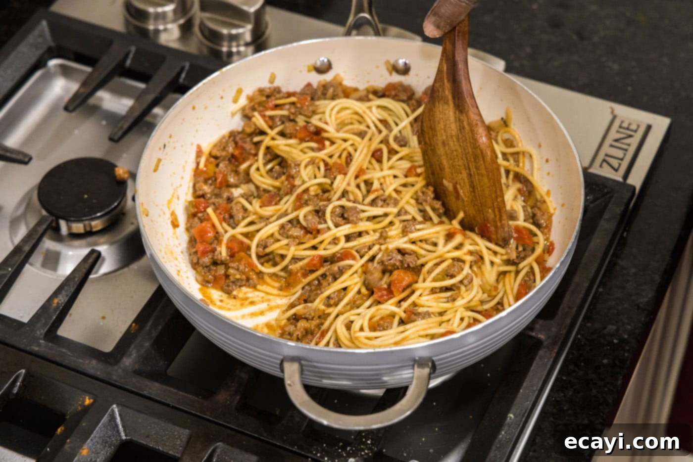 Tex-Mex Spaghetti 9 mixing spaghetti into taco seasoned ground beef with tomatoes and onion