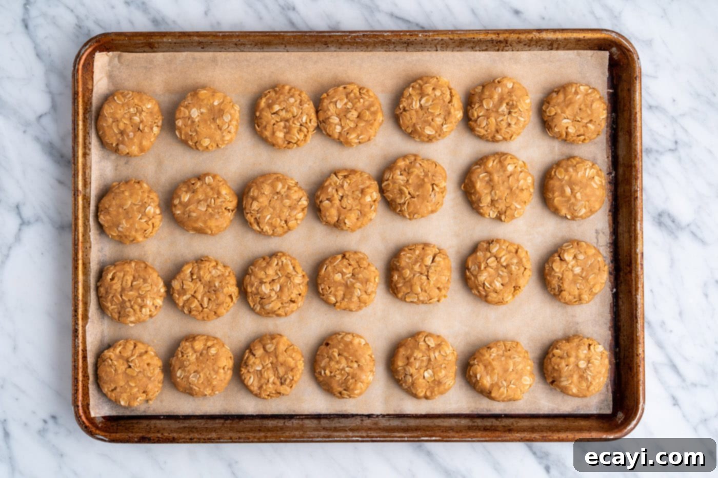 Peanut Butter Bliss Bites 16 No Bake Peanut Butter Cookies arranged on a parchment-lined baking sheet, allowing them to set