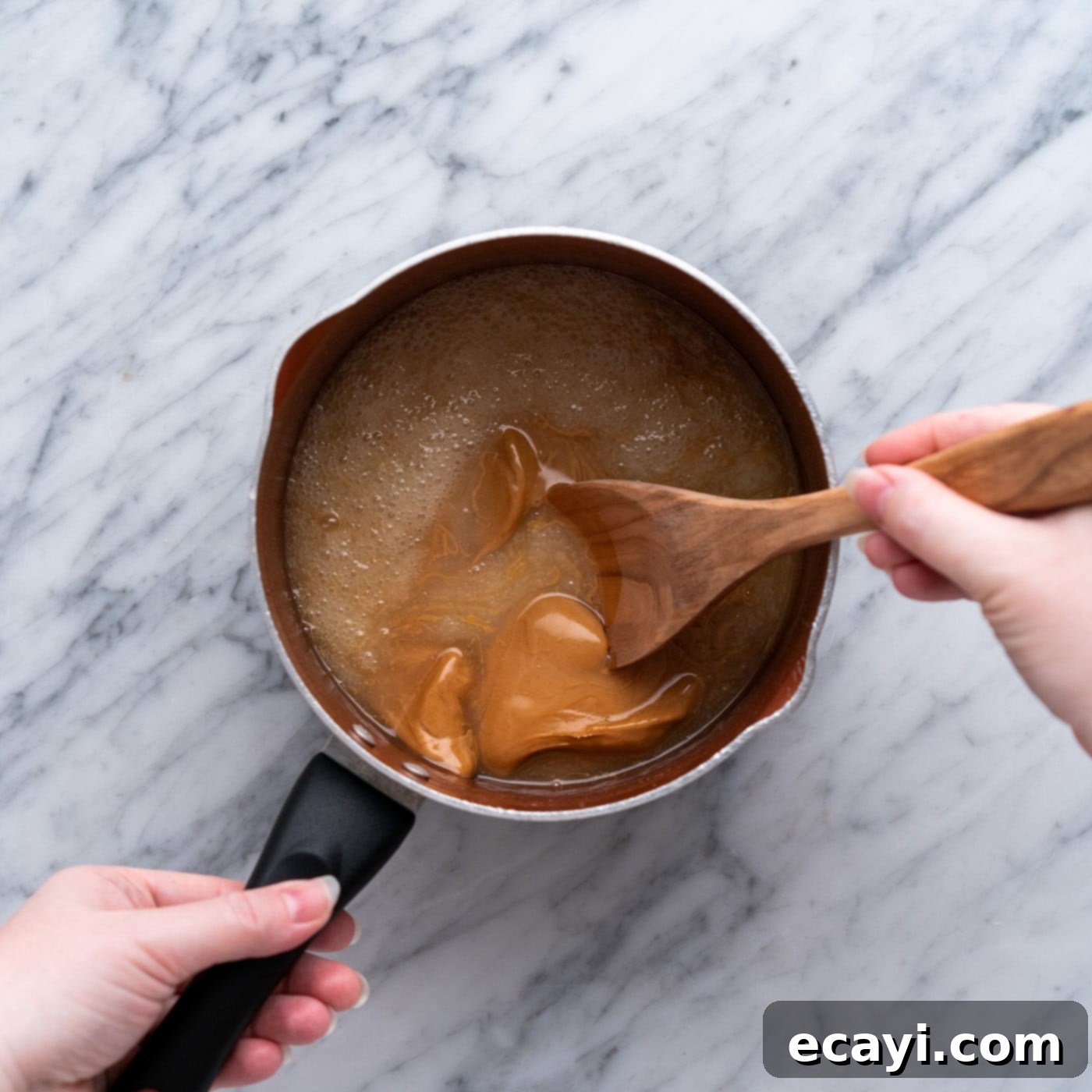 Peanut Butter Bliss Bites 10 A wooden spoon stirring the peanut butter cookie mixture in a pan until smooth