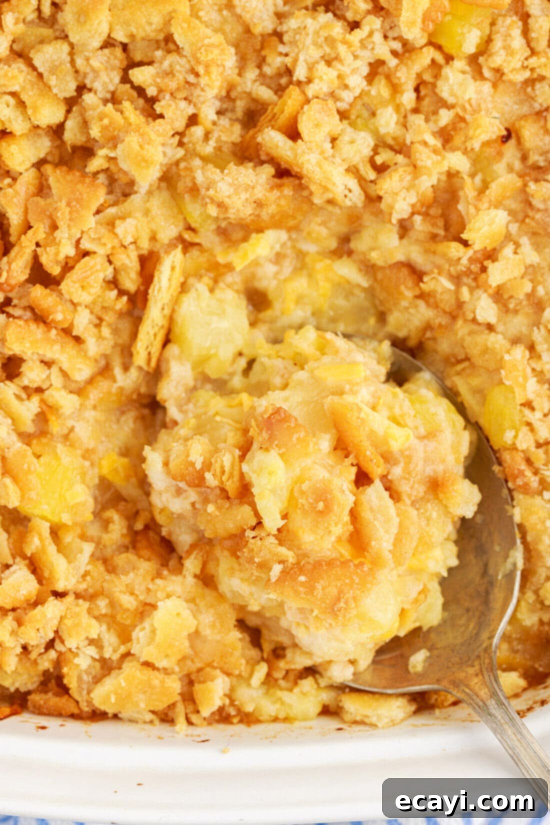 Sweet Pineapple Bake 12 Close up photo of a spoon in a pan of Pineapple Casserole