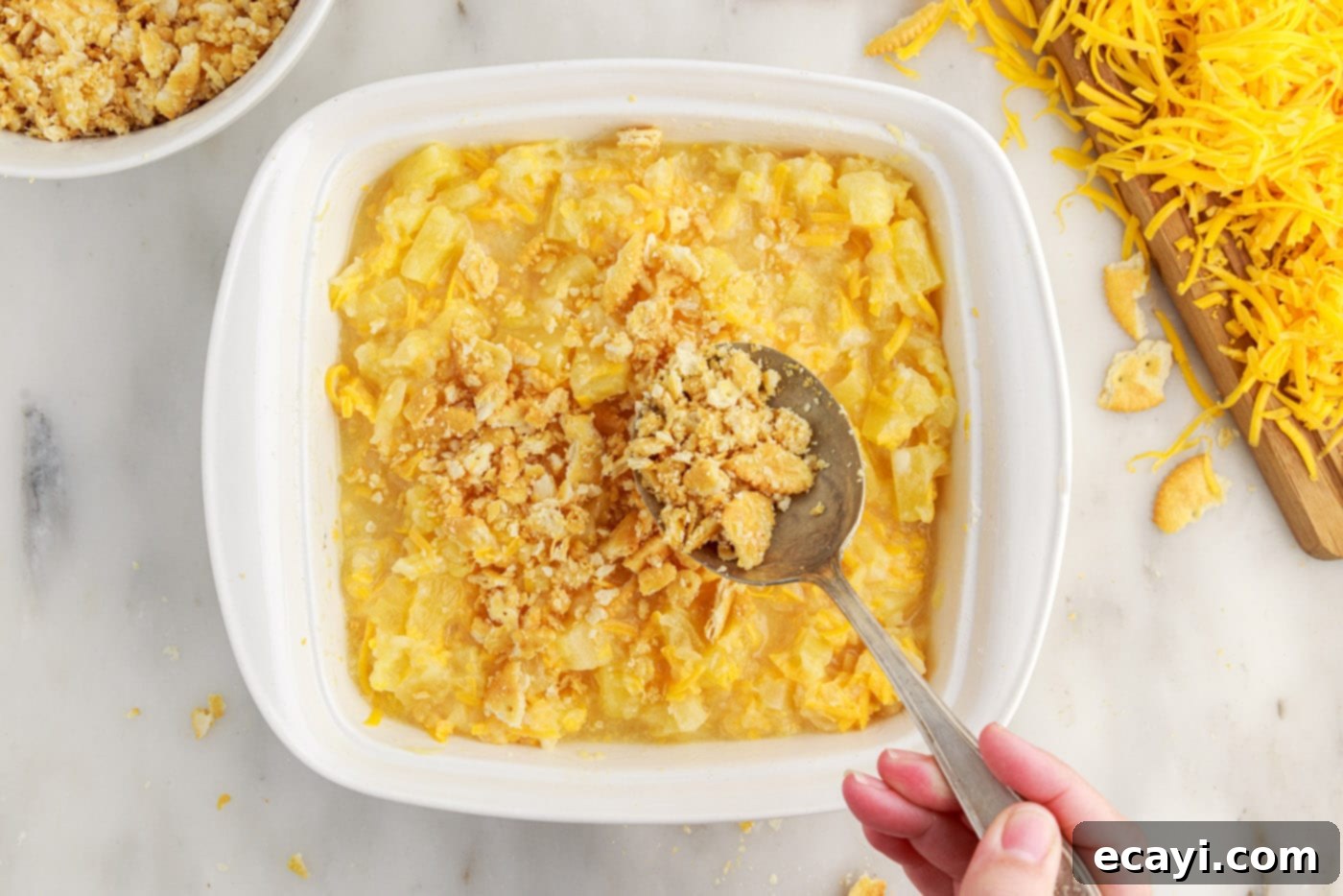 Sweet Pineapple Bake 9 spreading ritz cracker topping over pineapple casserole