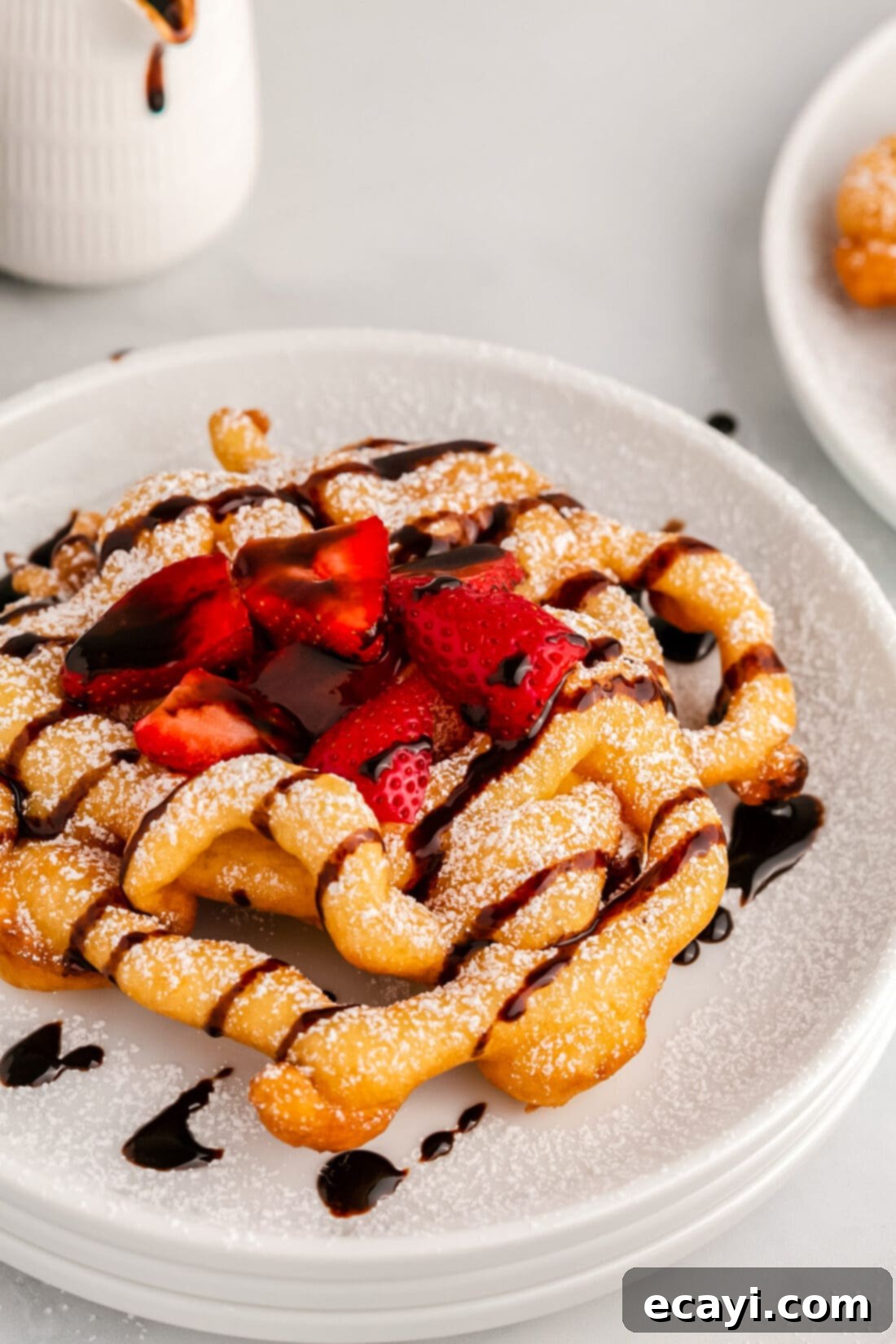 Carnival Classic: The Art of Funnel Cake 2 Close up photo of a Funnel Cake topped with chocolate sauce and strawberries