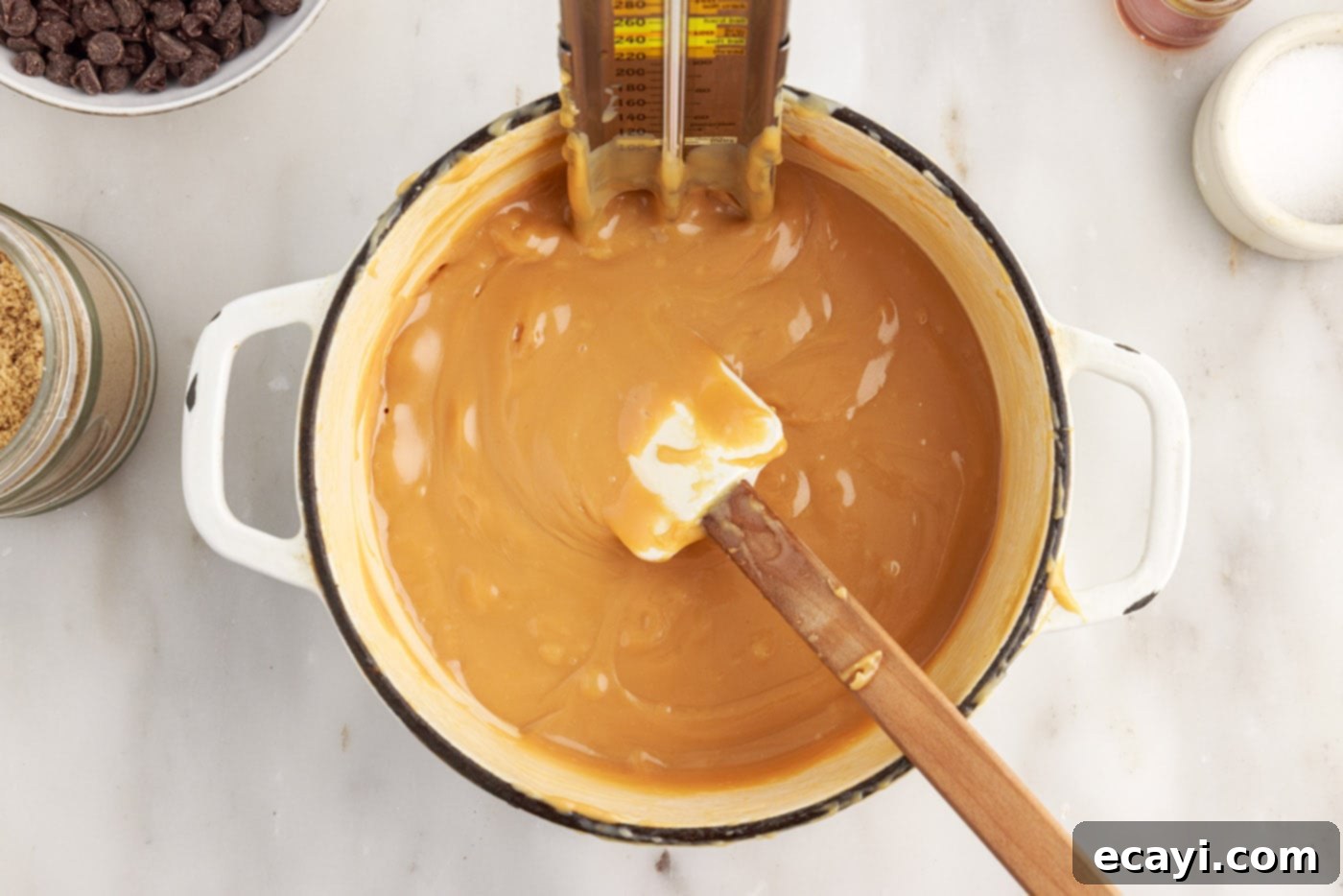 Golden Caramel Indulgence 12 A candy thermometer measuring the temperature of caramel as it cooks in a saucepan.
