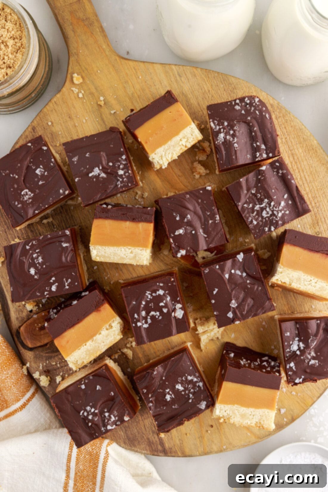 Golden Caramel Indulgence 18 A selection of delicious Millionaire’s Bars presented on a stylish wooden board, highlighting their inviting appearance.