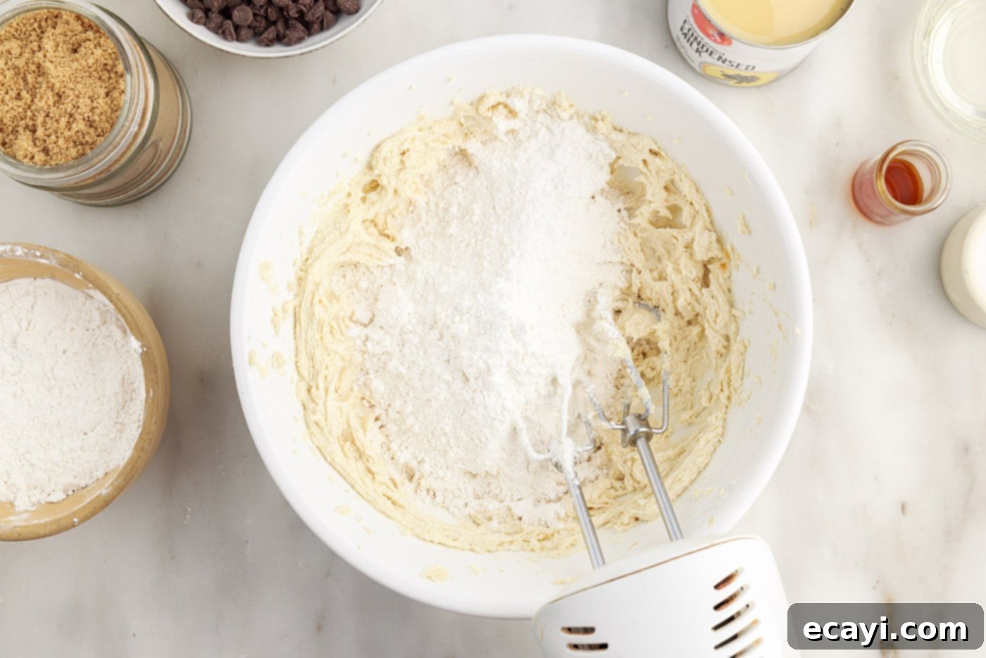 Golden Caramel Indulgence 7 Adding cake flour to the shortbread dough in a mixing bowl.