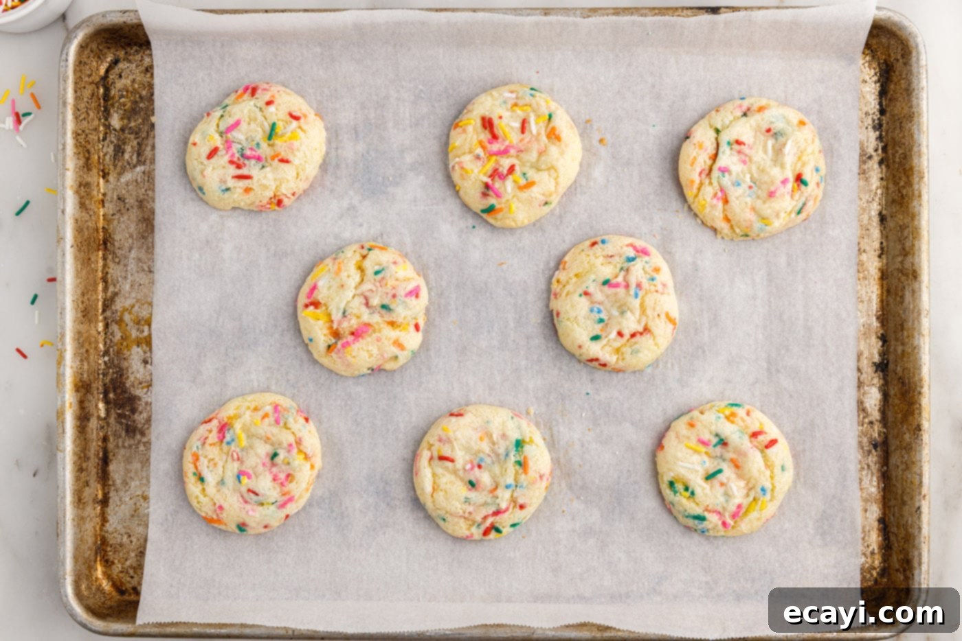 Easy Funfetti Cake Mix Cookies 8 Freshly baked funfetti cookies, golden and perfectly puffed, cooling on a baking sheet straight from the oven.