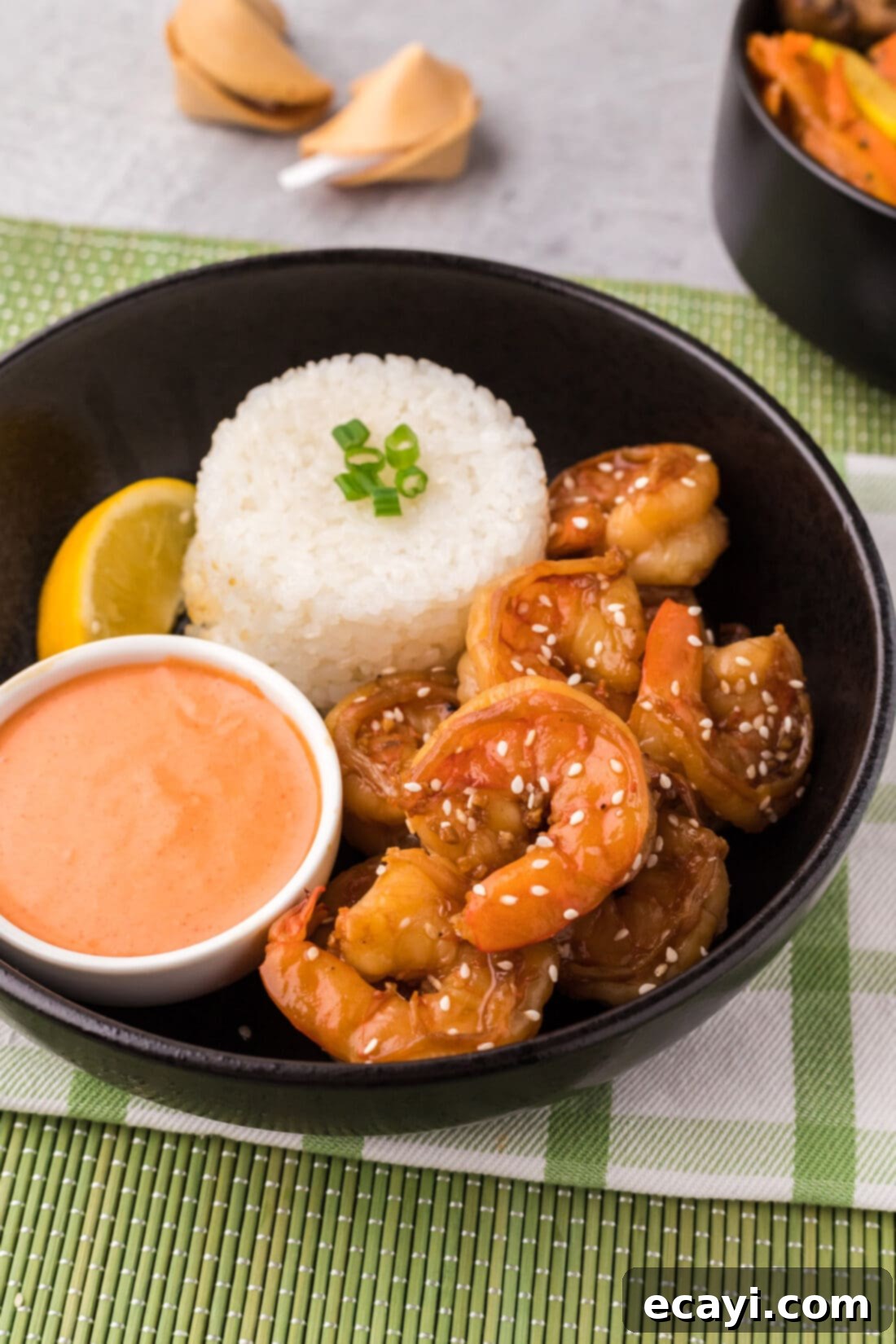 Sizzling Hibachi Shrimp 3 A vibrant bowl of Hibachi Shrimp, served alongside fluffy white rice and a creamy side of Yum Yum Sauce, ready to be enjoyed.