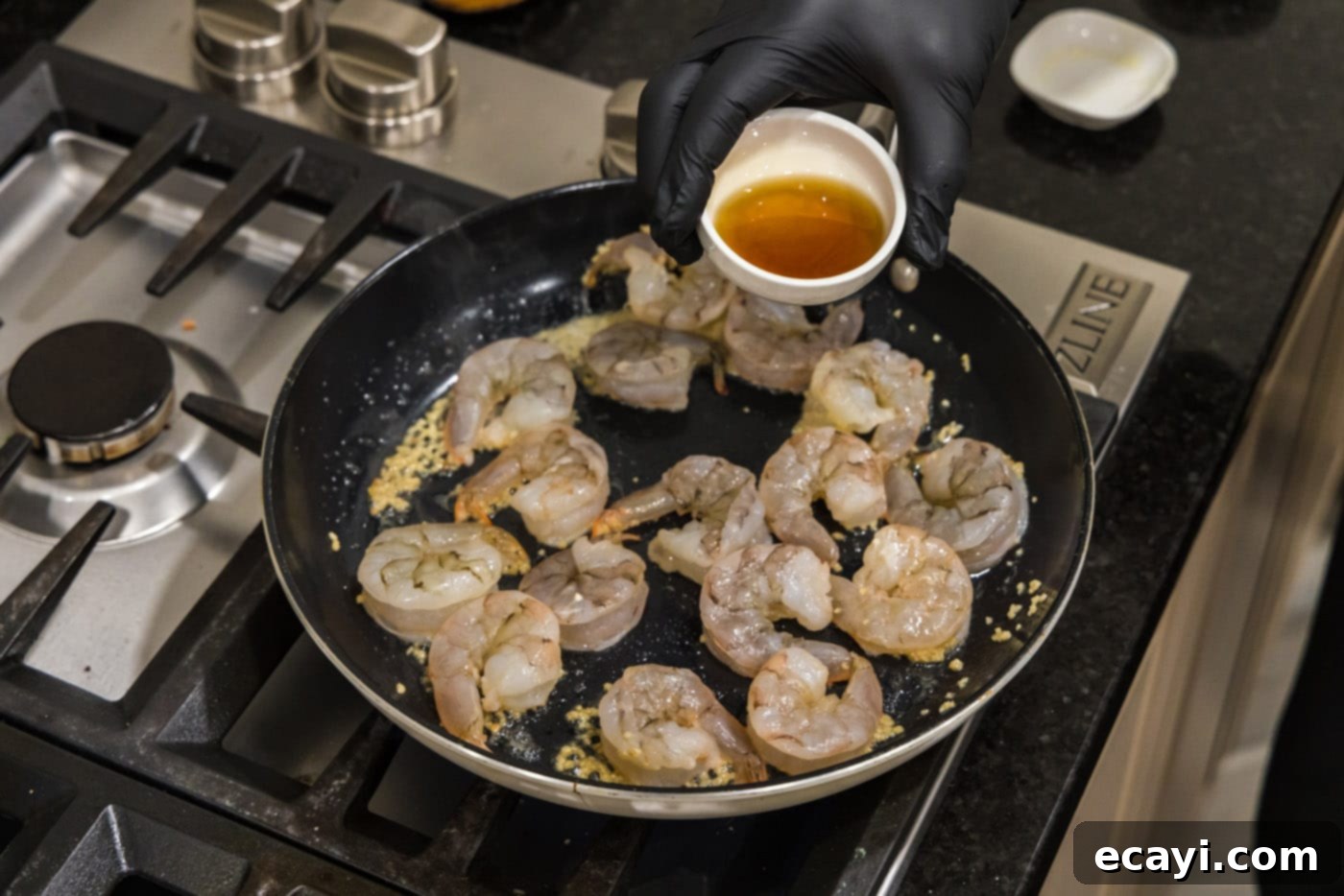 Sizzling Hibachi Shrimp 7 A stream of flavorful sauce being poured over the sizzling shrimp in the skillet, infusing it with hibachi taste.