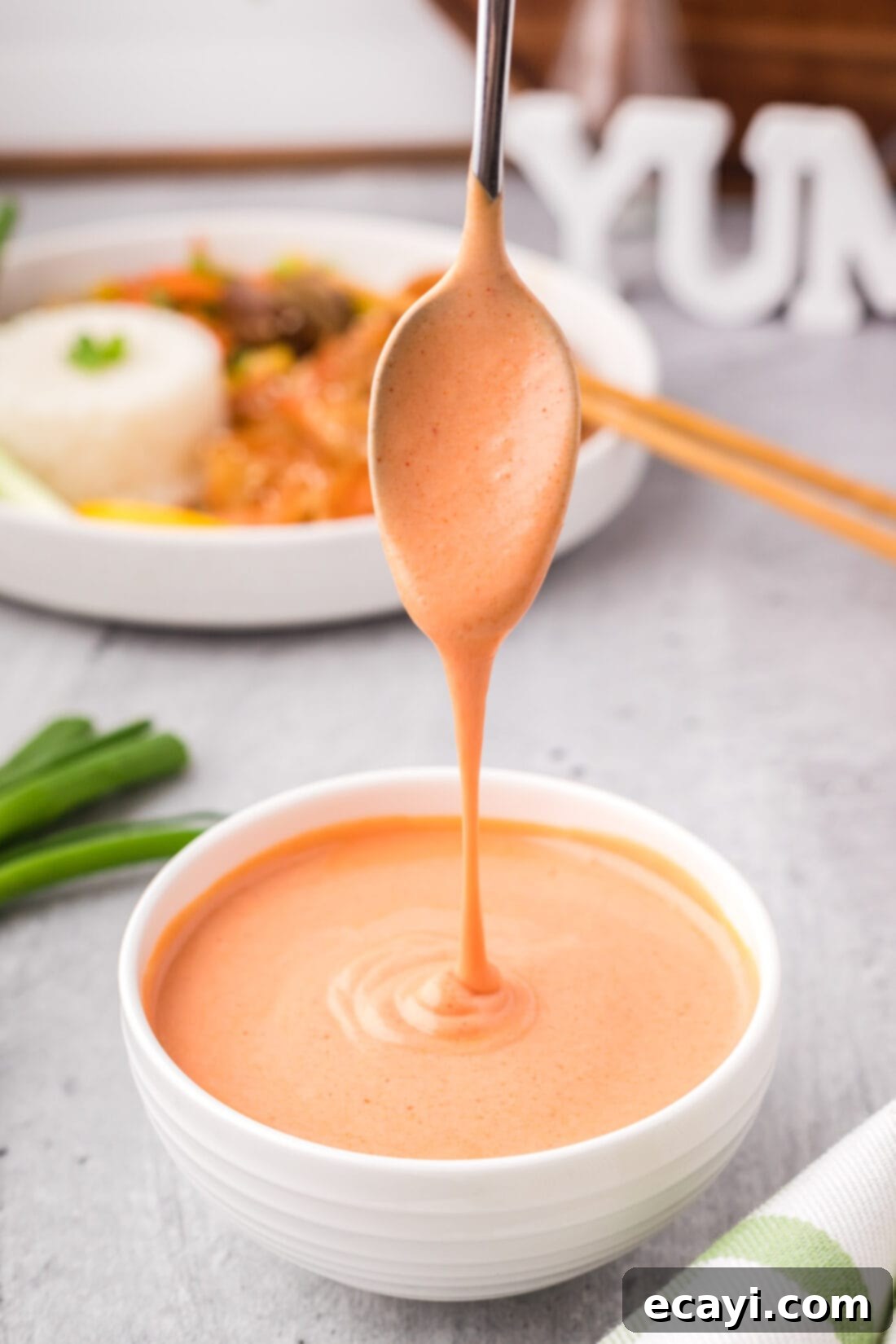 Golden Harmony Sauce 2 Yum Yum Sauce being drizzled off of a spoon