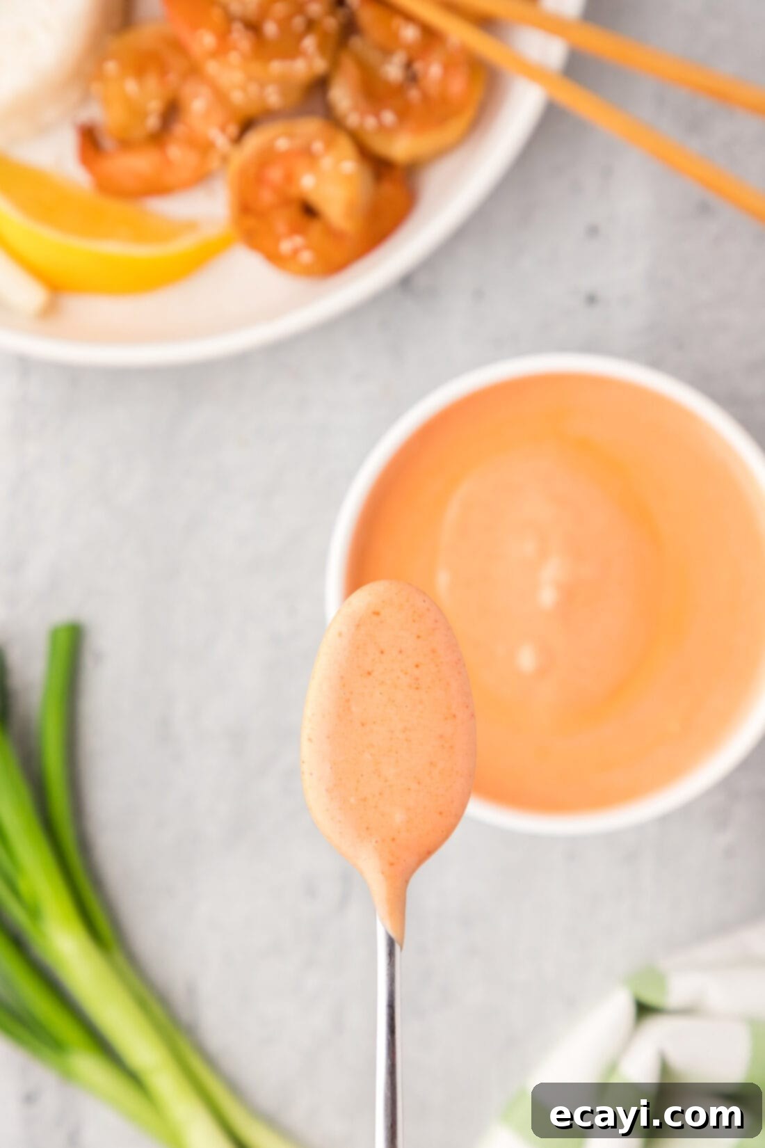 Golden Harmony Sauce 7 Spoonful of Yum Yum Sauce held over the bowl of Yum Yum Sauce